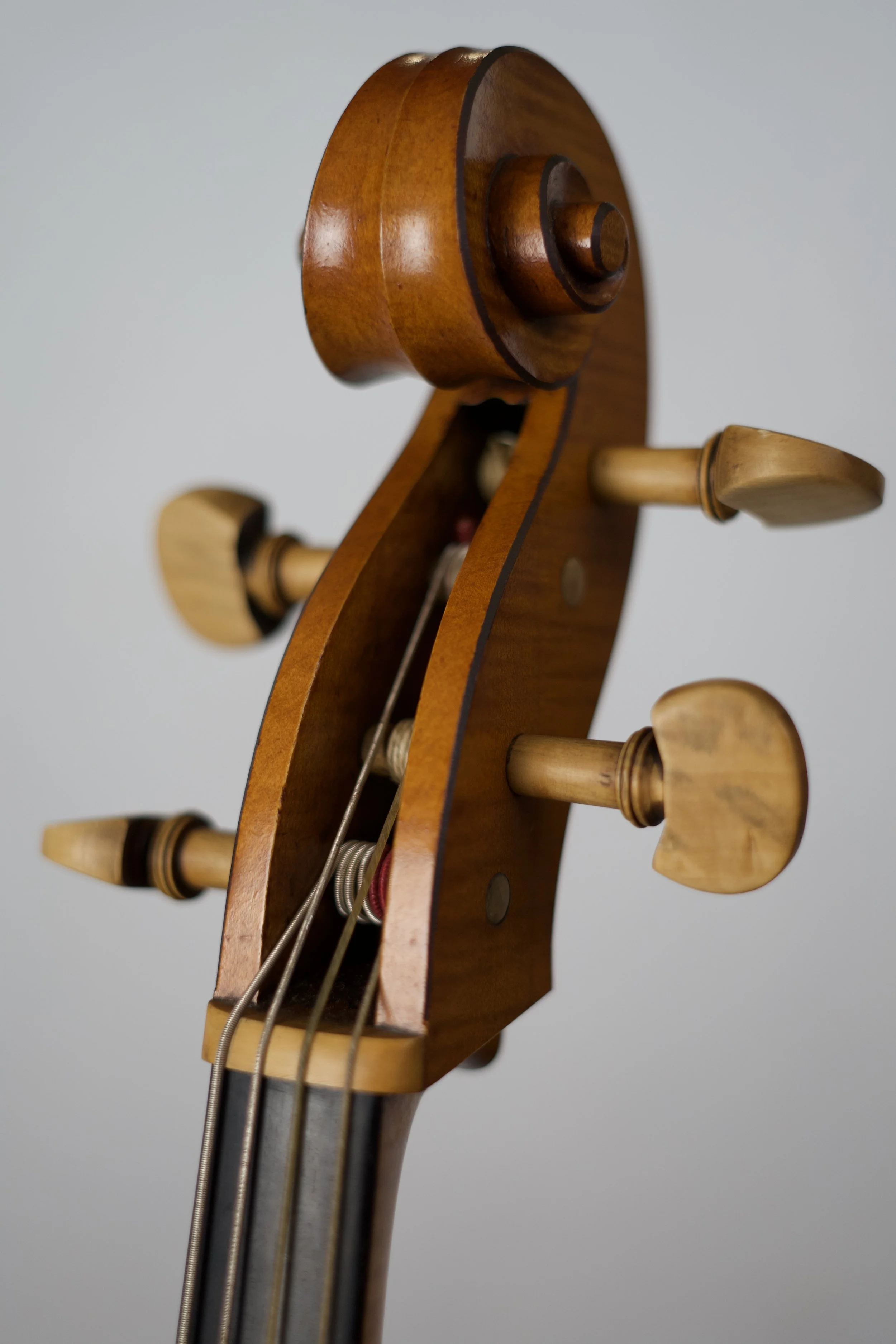 Close-up of the scroll and tuning pegs of a wooden acoustic guitar.