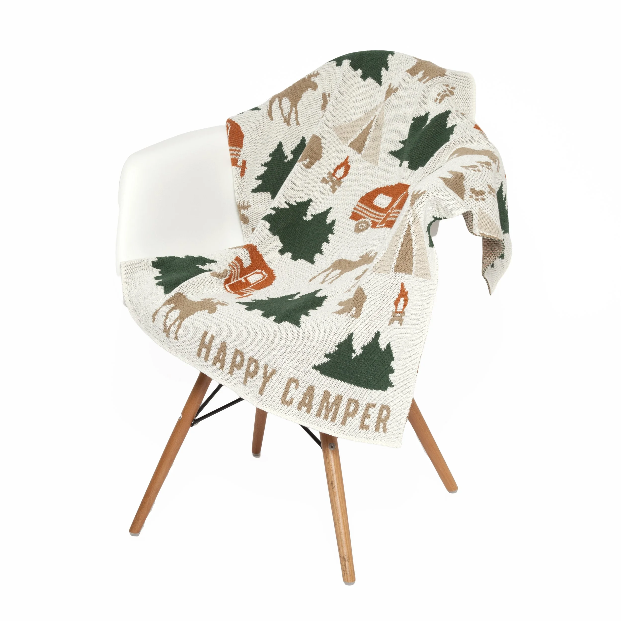 Chair with a festive blanket featuring trees, moose, lanterns, and the words 'Happy Camper' draped over its back.