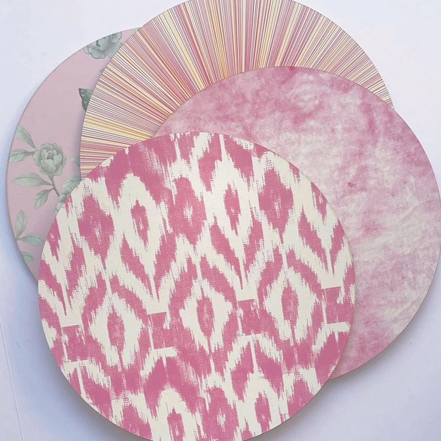 Set of layered paper or fabric circles with various pink patterns, including floral, abstract, and geometric designs.