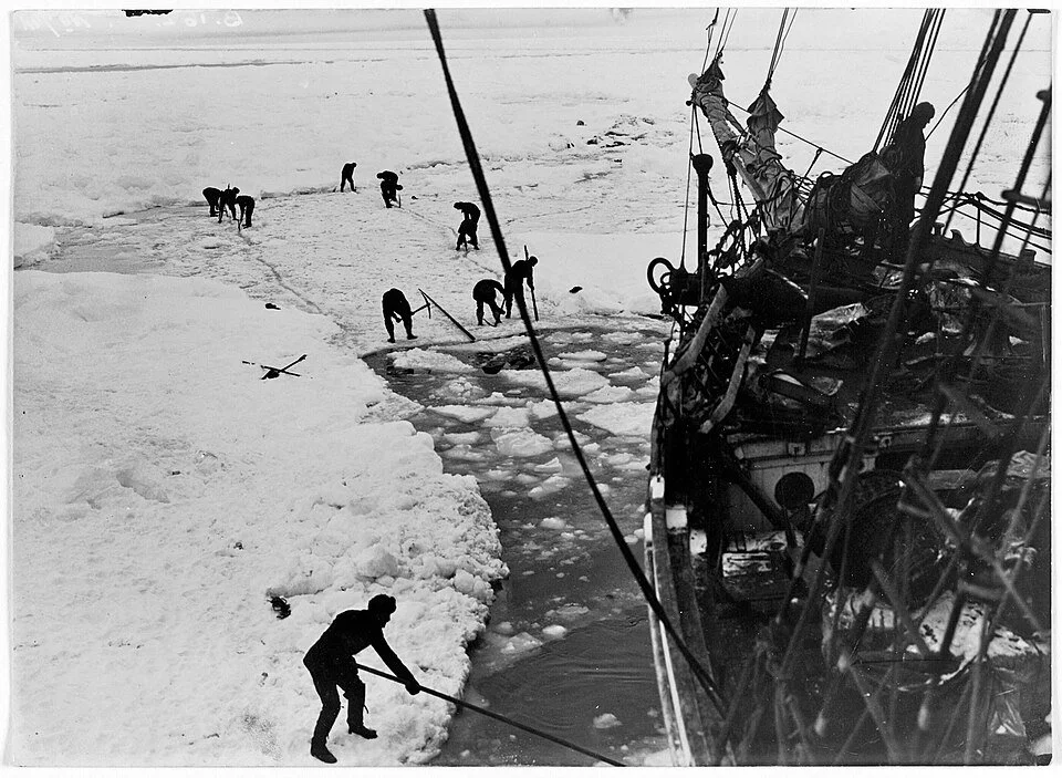 men trying to cut a ship out of a frozen sea