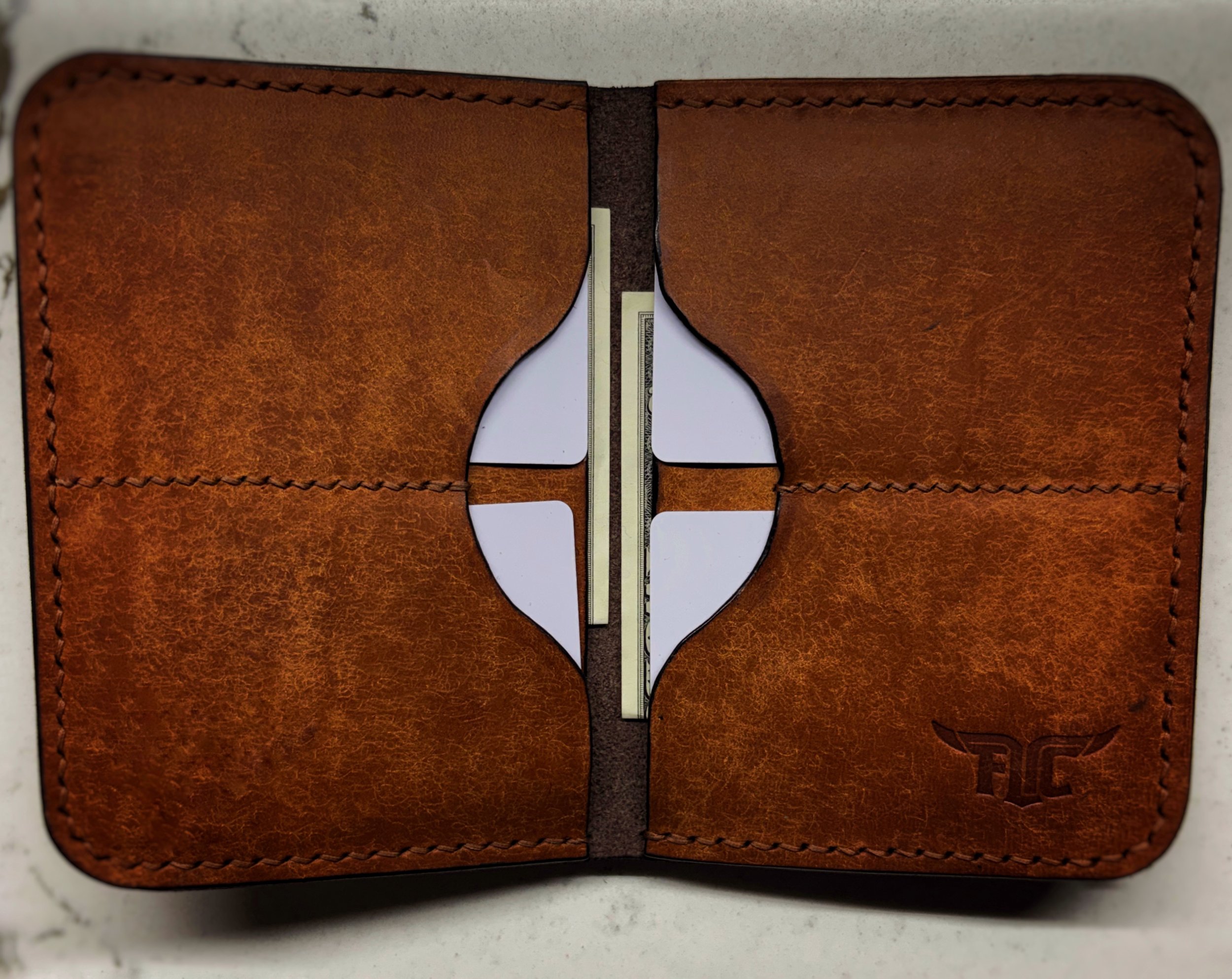 Open brown leather wallet with cash and cards inside