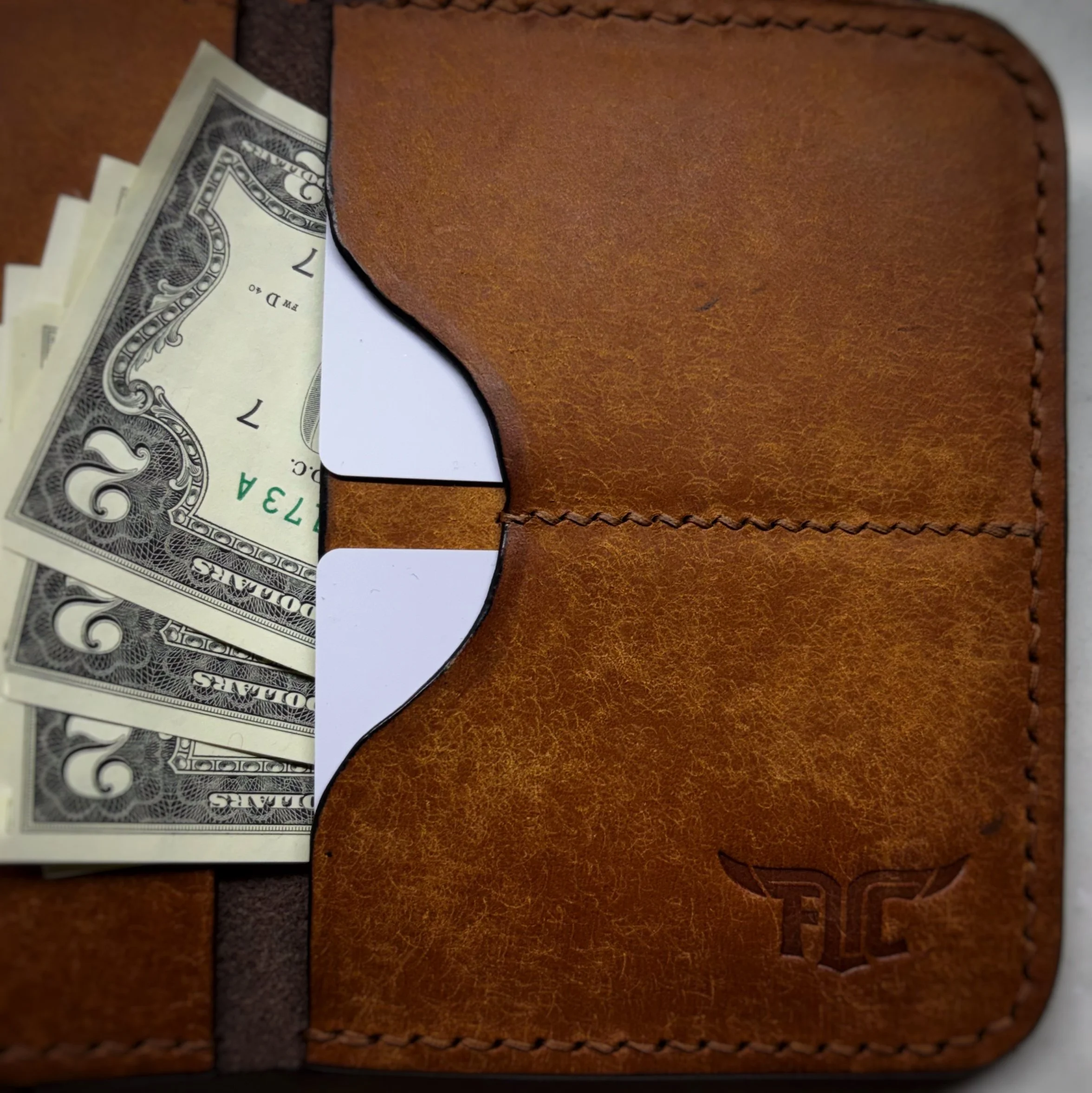 A leather wallet with dollar bills partially visible from its side pocket.