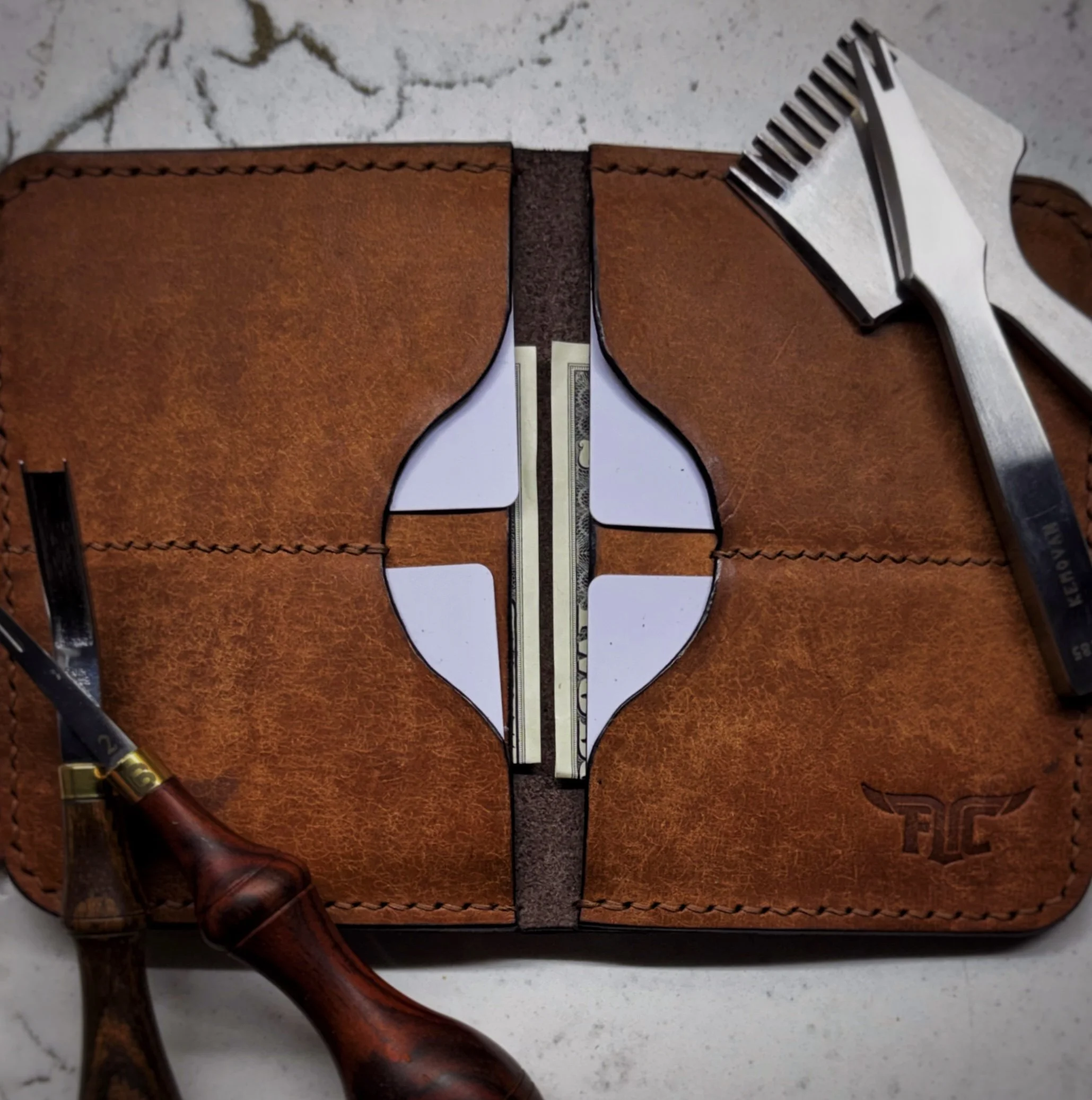 A leather wallet with a dollar bill inside and various grooming tools placed alongside it on a marble surface.