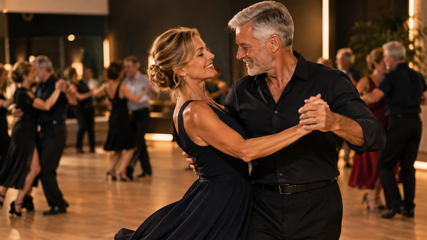 Coppia che sorride mentre balla in una sala elegante: imparare a ballare a 50 anni è un’esperienza piena di eleganza e connessione.