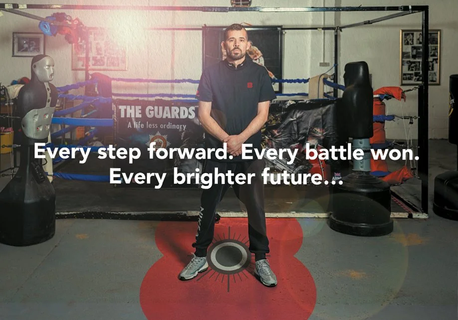 A man in athletic clothing standing inside a boxing gym. The background features a boxing ring, punching bags, and gym equipment. Overlay text reads, 'Every step forward. Every battle won. Every brighter future...'
