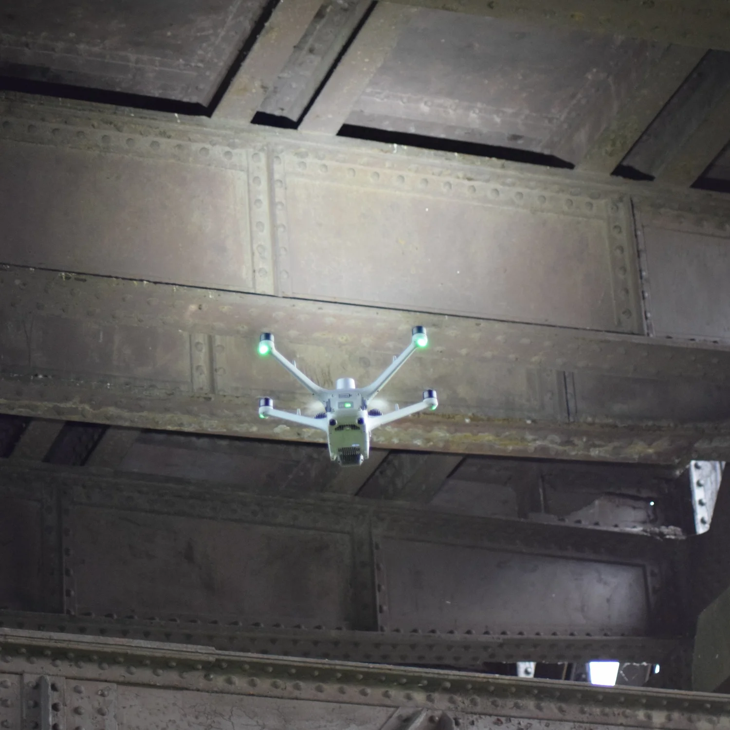 Drone navigating confined spaces to capture high-resolution imagery of bridge structural connections.