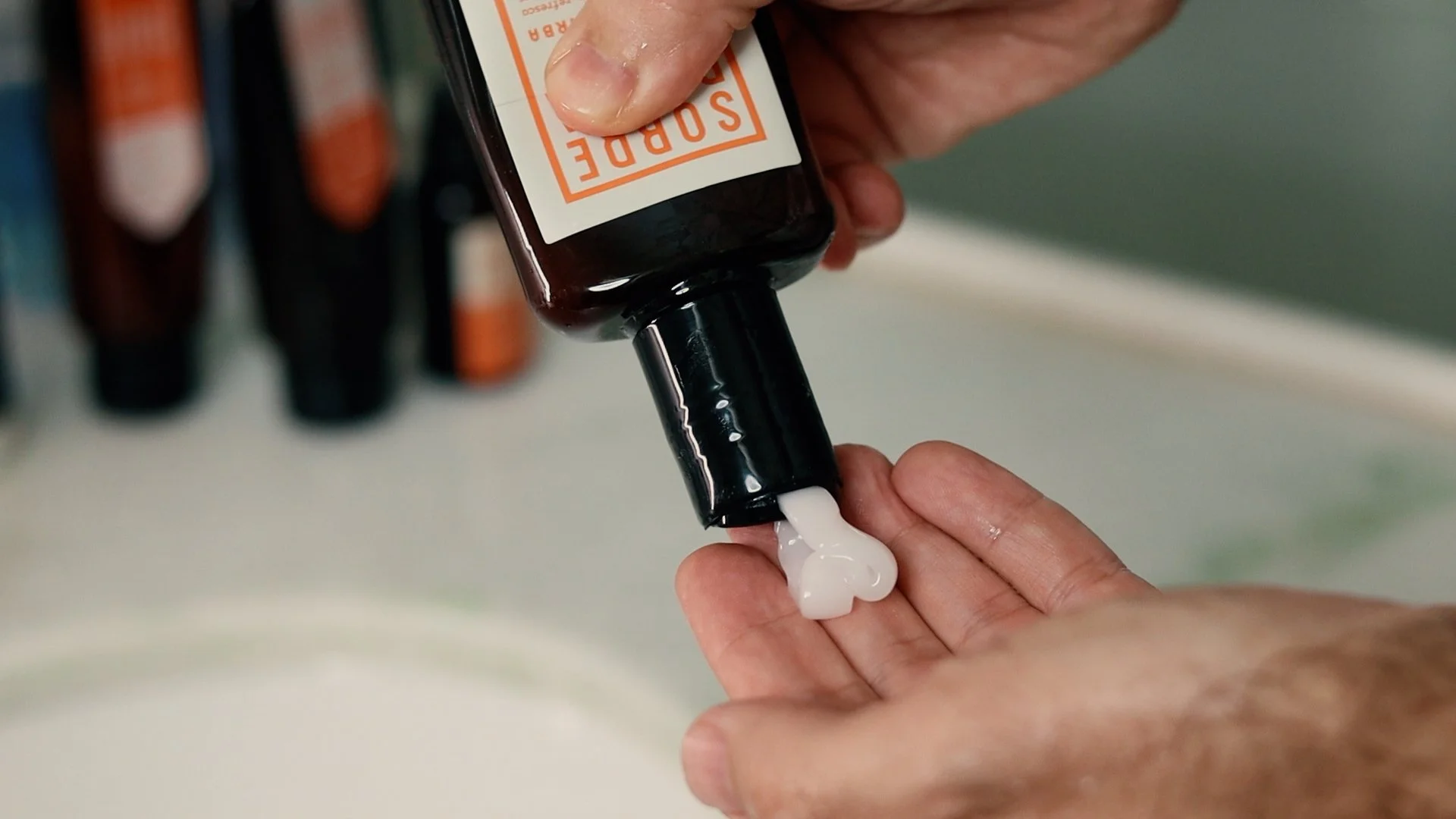 Detalhe do Balm de Barba Sobrebarba na mão mostrando sua textura cremosa e refrescante