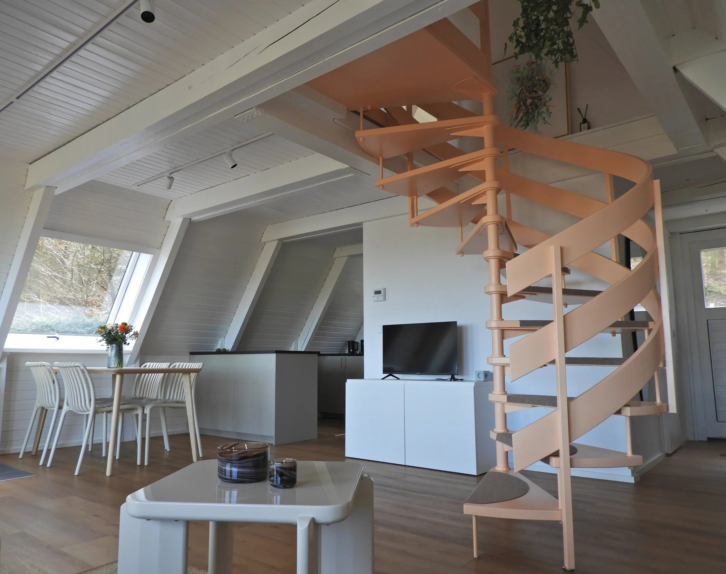 Innenansicht eines modernen, helle Wohnung mit hohen Decken, großen Dachfenstern, Treppe und Esstisch