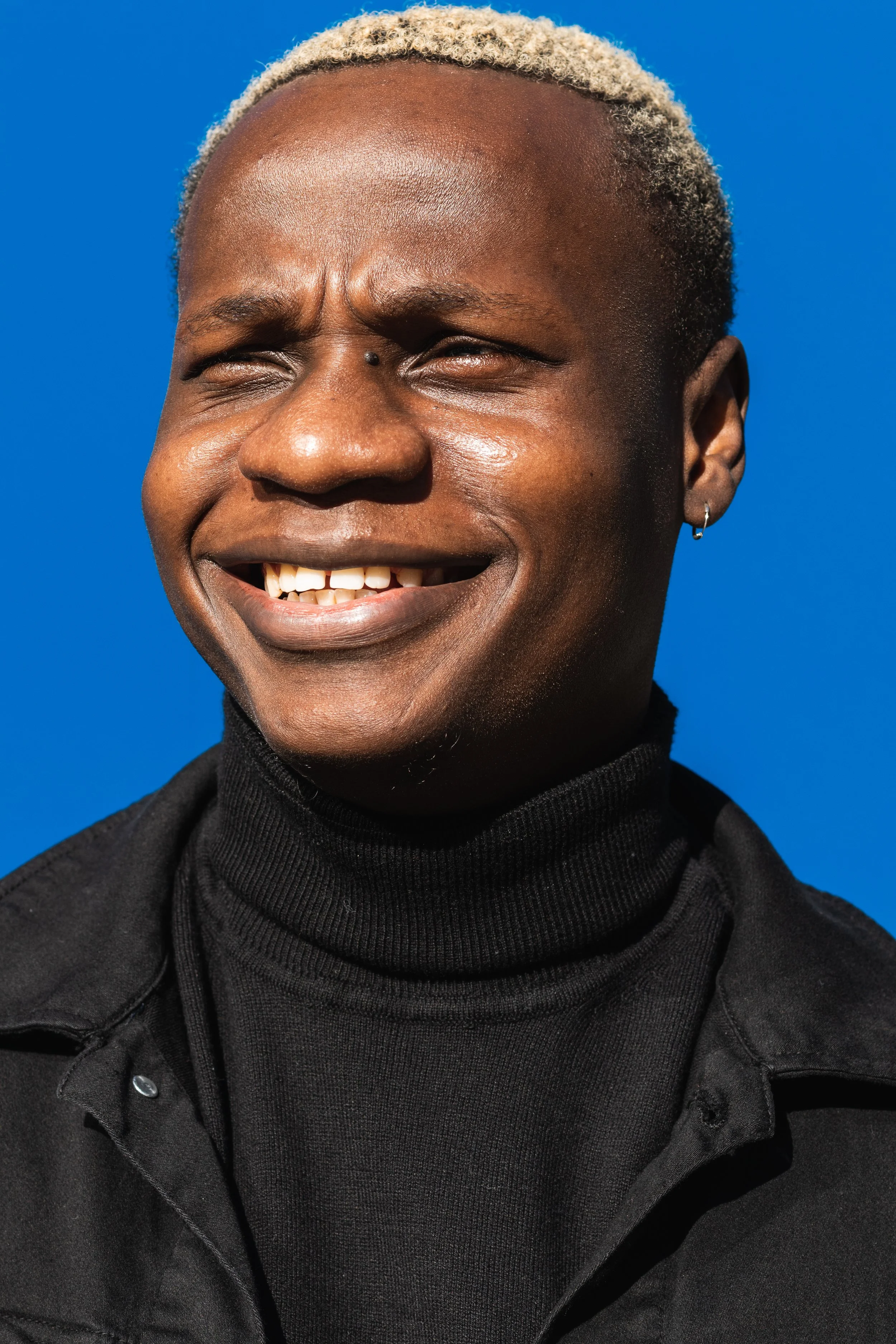 smiling-young-adult-in-front-of-blue-background-2026-03-25-01-00-58-utc.jpg