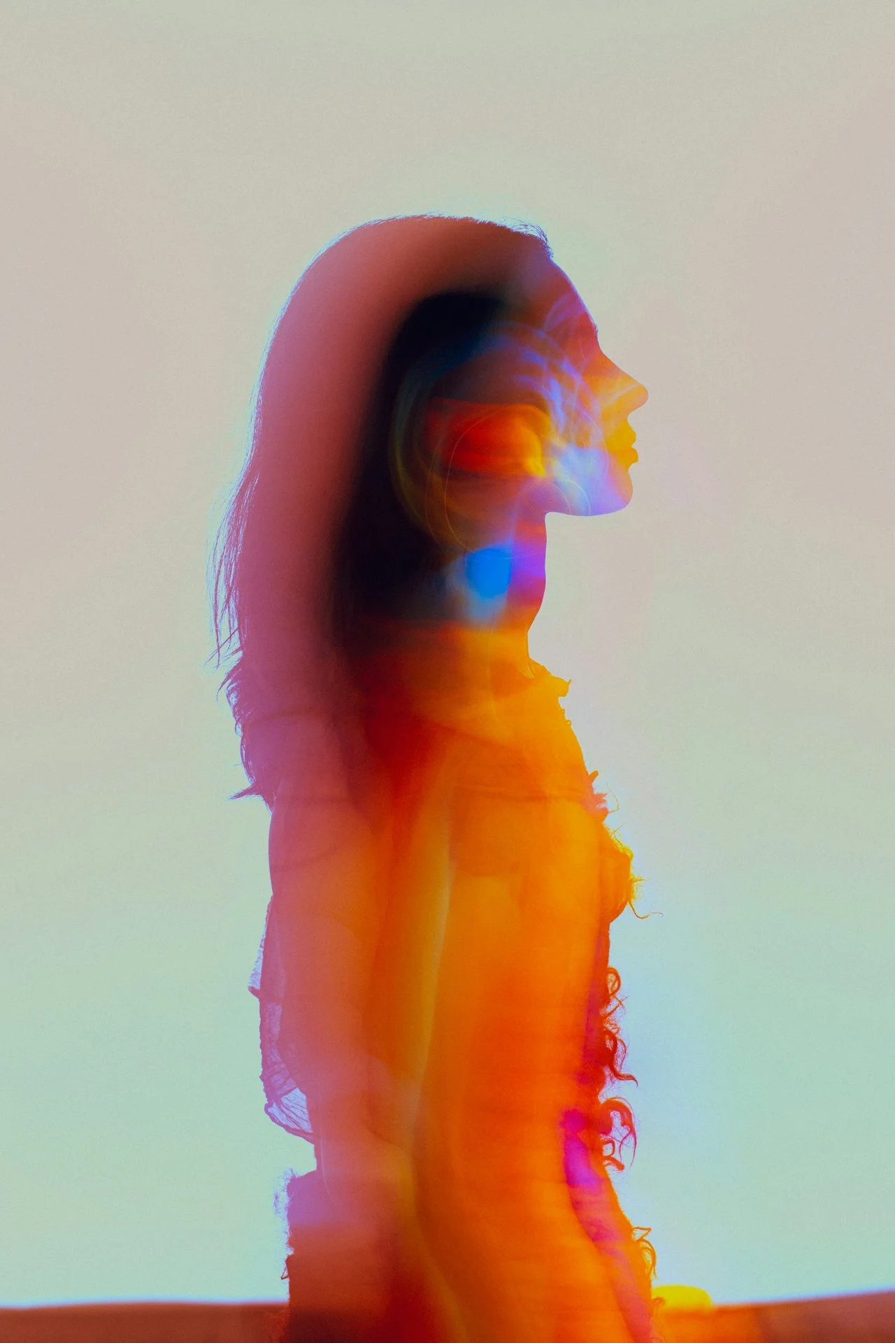 Abstract double-exposure portrait of a woman with colorful light effects, representing creative brand identity and web design by Knight Theory™ in Los Angeles.