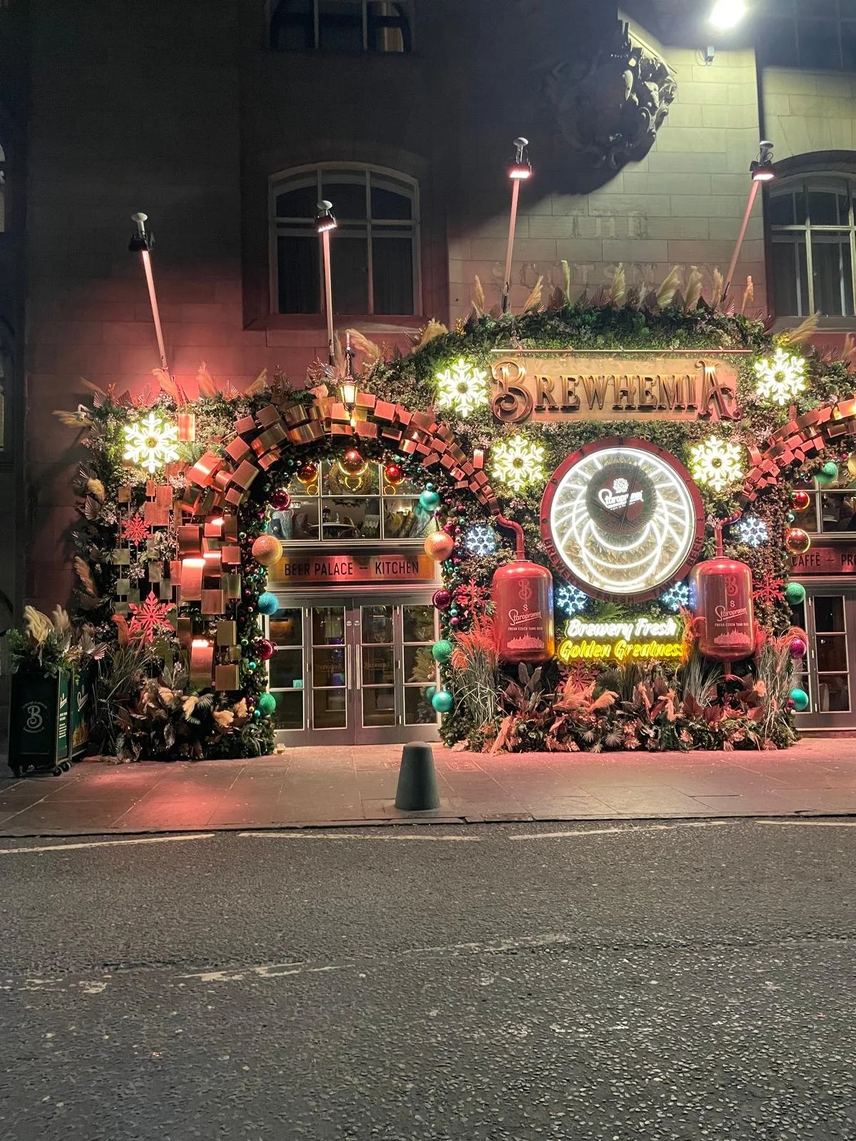 Decorated storefront with Christmas and beer-themed decorations, neon signs, and a large circular beer sign with the text 'Brewhemia' and 'Golden Greatness'.