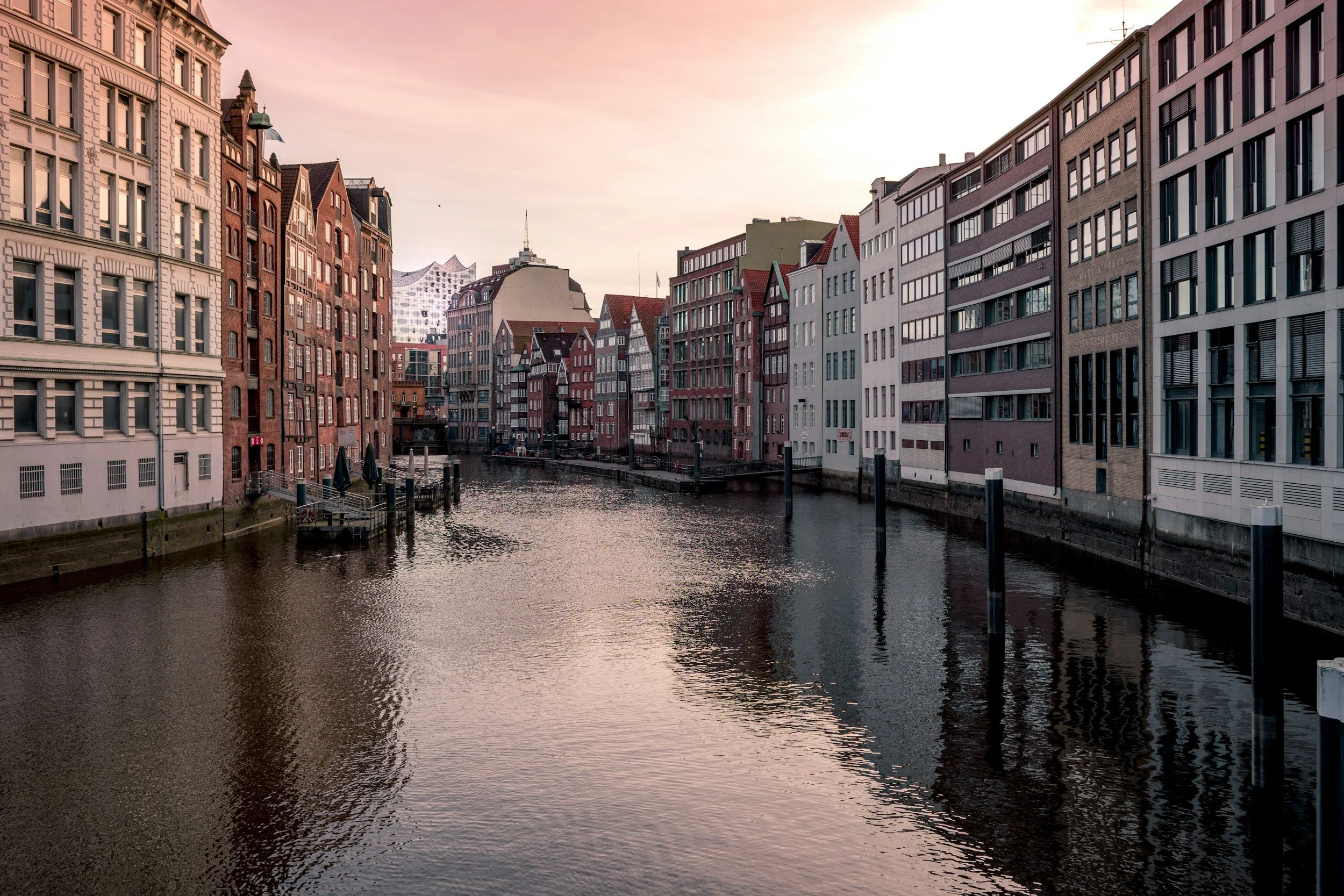 Blick auf ein Kanal mit bunten historischen Gebäuden auf beiden Seiten bei Sonnenuntergang in Hamburg, Deutschland.