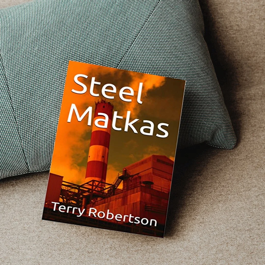 A book titled 'Steel Matkas' by Terry Robertson leaning against a blue textured pillow on a beige fabric surface.