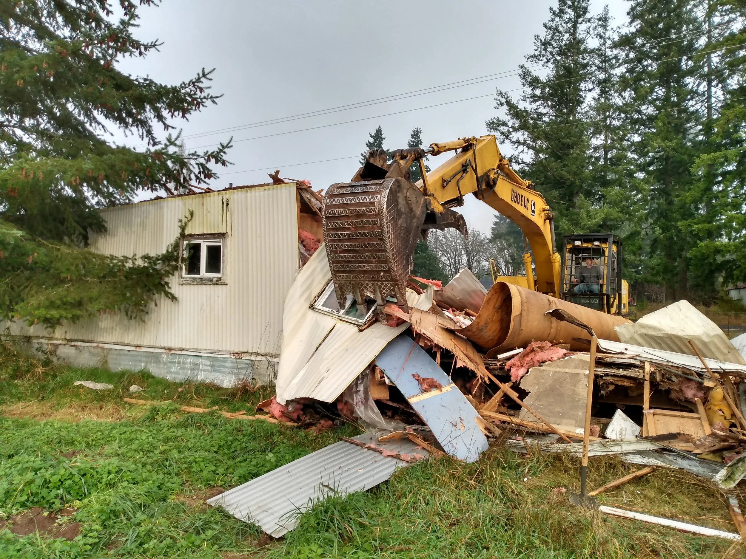 Demolishing a mobile home park with an excavator