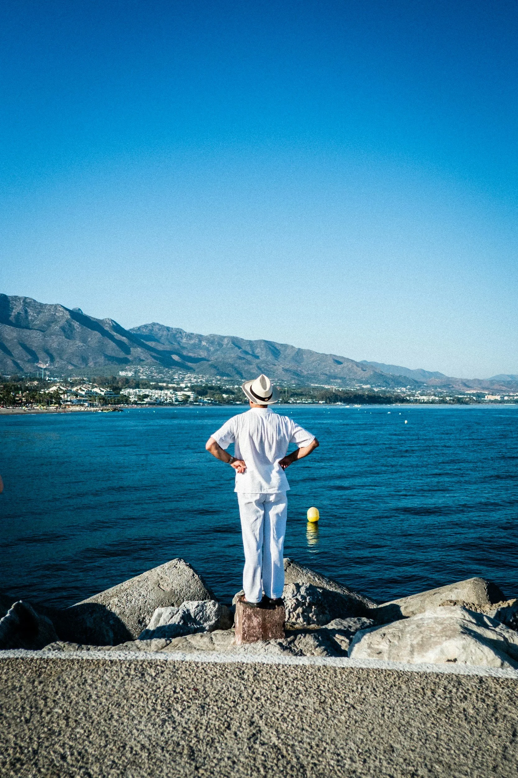 Expat man looking at the sea from a pier in Marbella, Spain