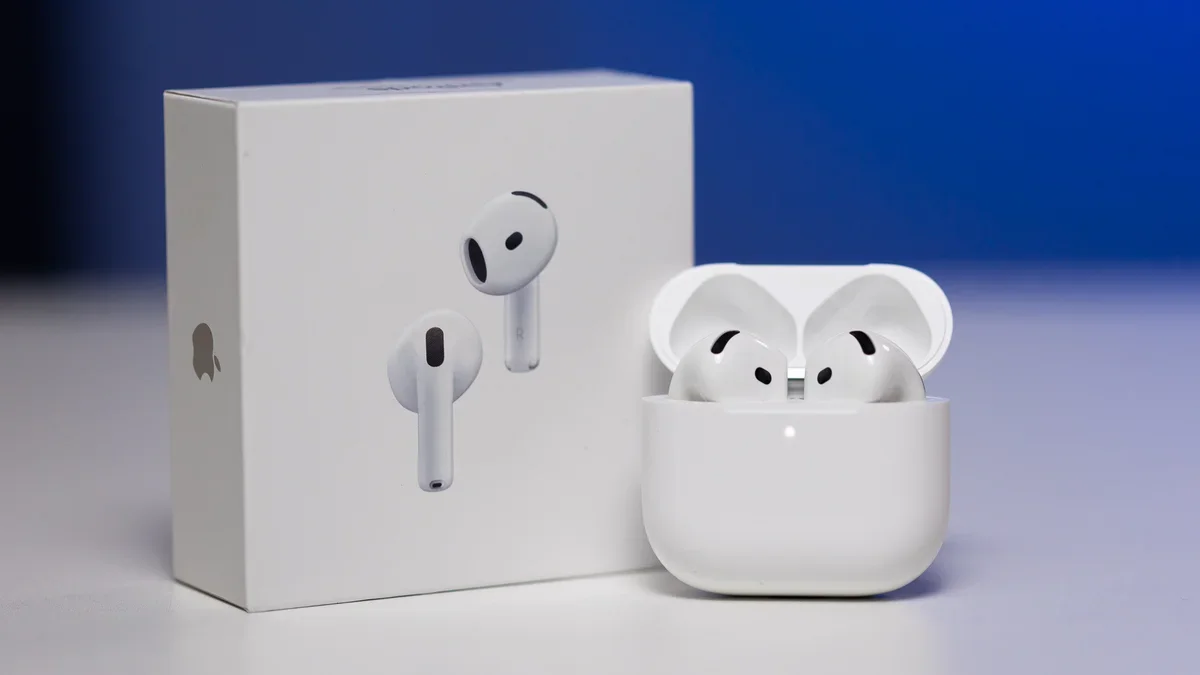 Apple AirPods Pro with charging case and retail box on a surface against a blue background.
