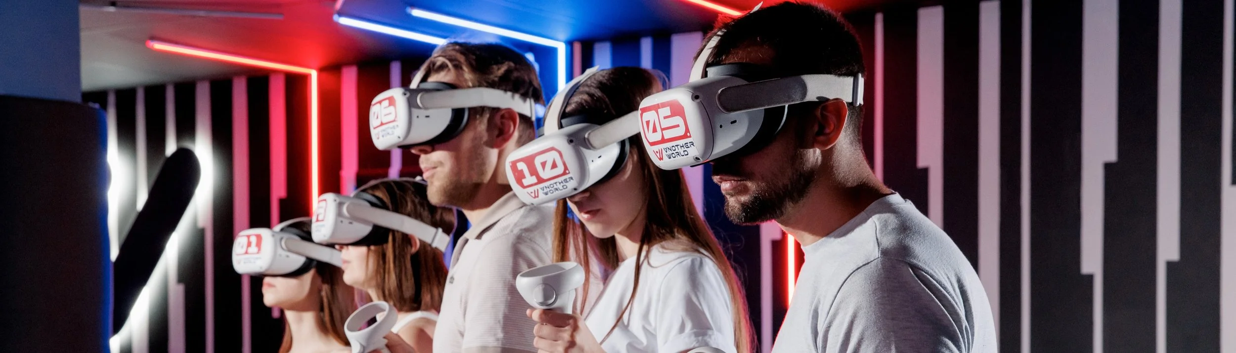 Grupo de personas usando gafas de realidad virtual en un entorno oscuro con luces de neón