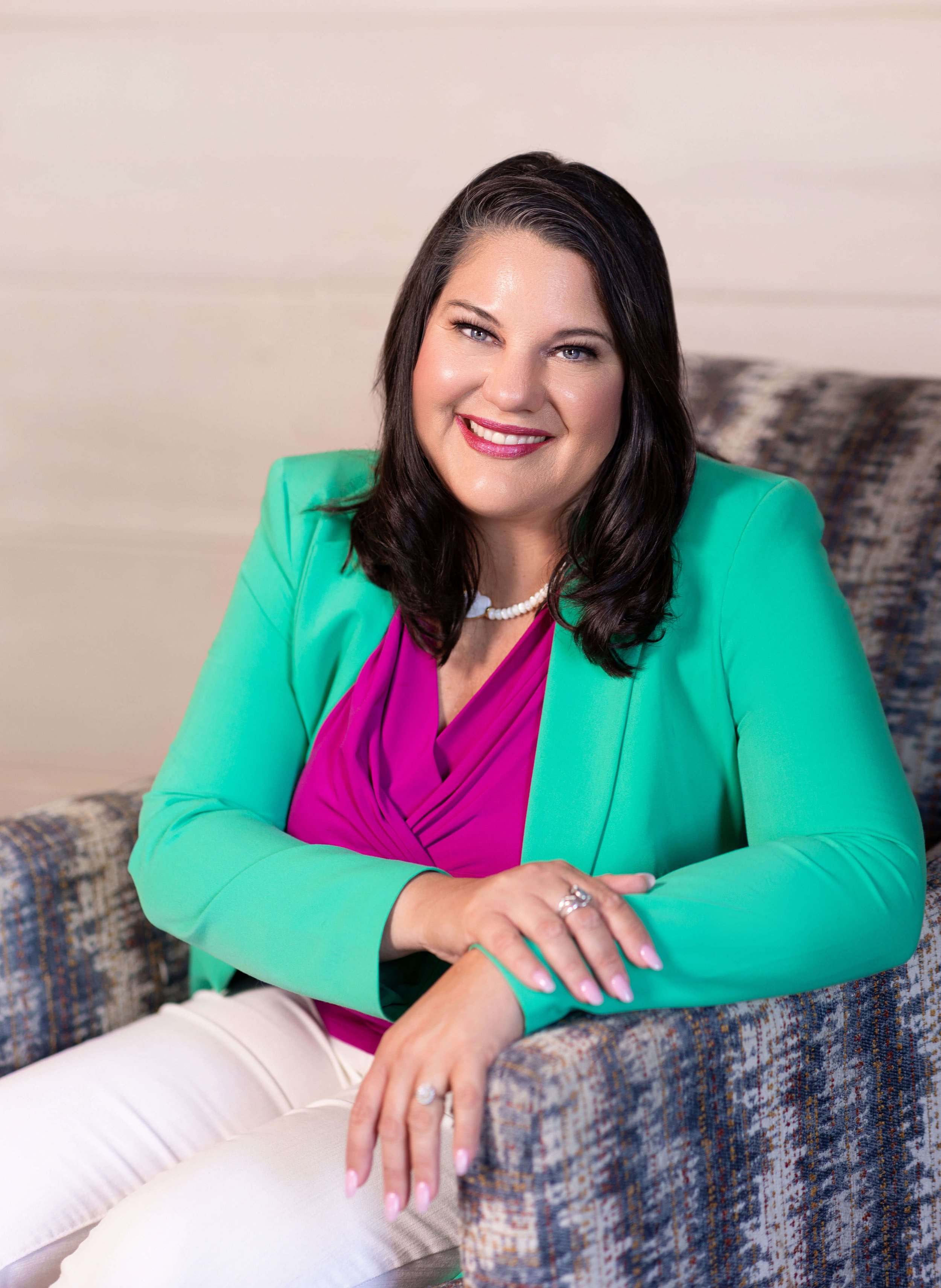 Shannon Villalba, founder of Heartsong Legal and intellectual property attorney, sitting in a chair smiling