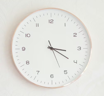 Round wall clock with a white face and black hands showing 2:15:25.