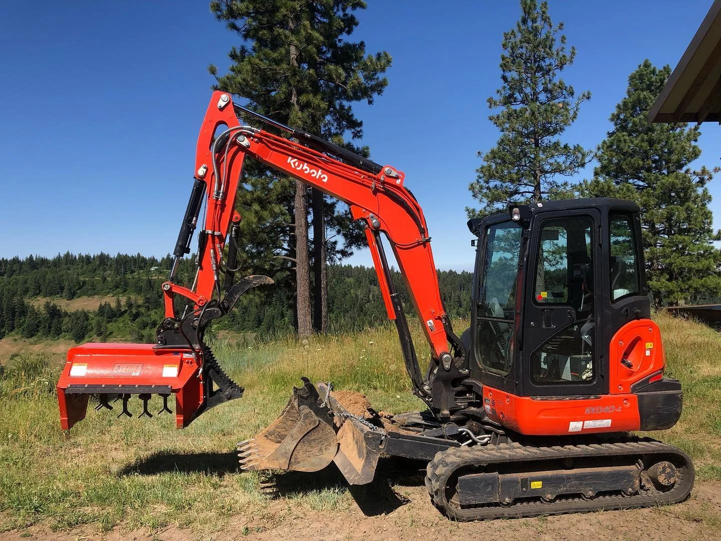 Flail mower on excavator for vegetation removal.