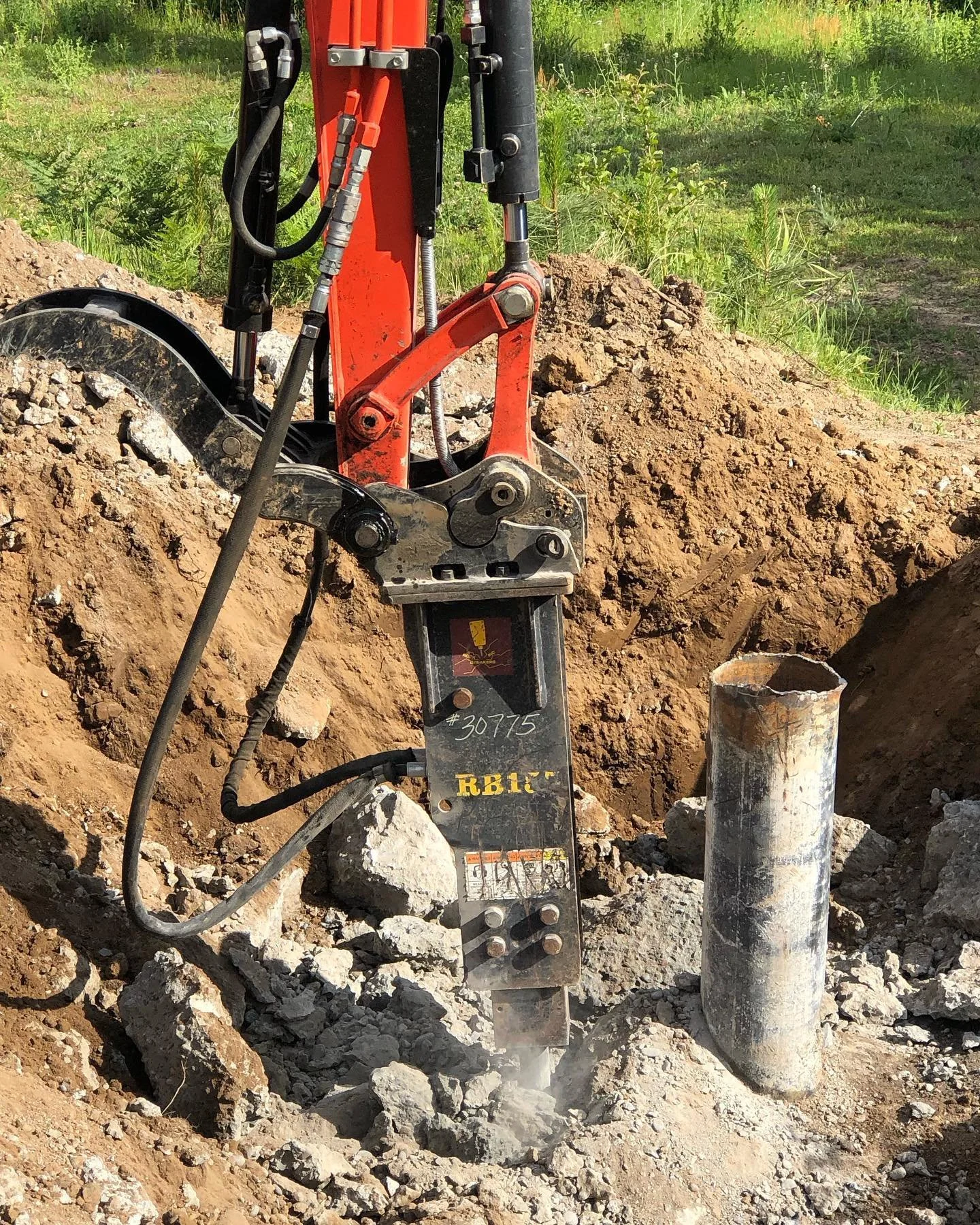 Close-up of an excavator working on a construction site breaking up concrete.