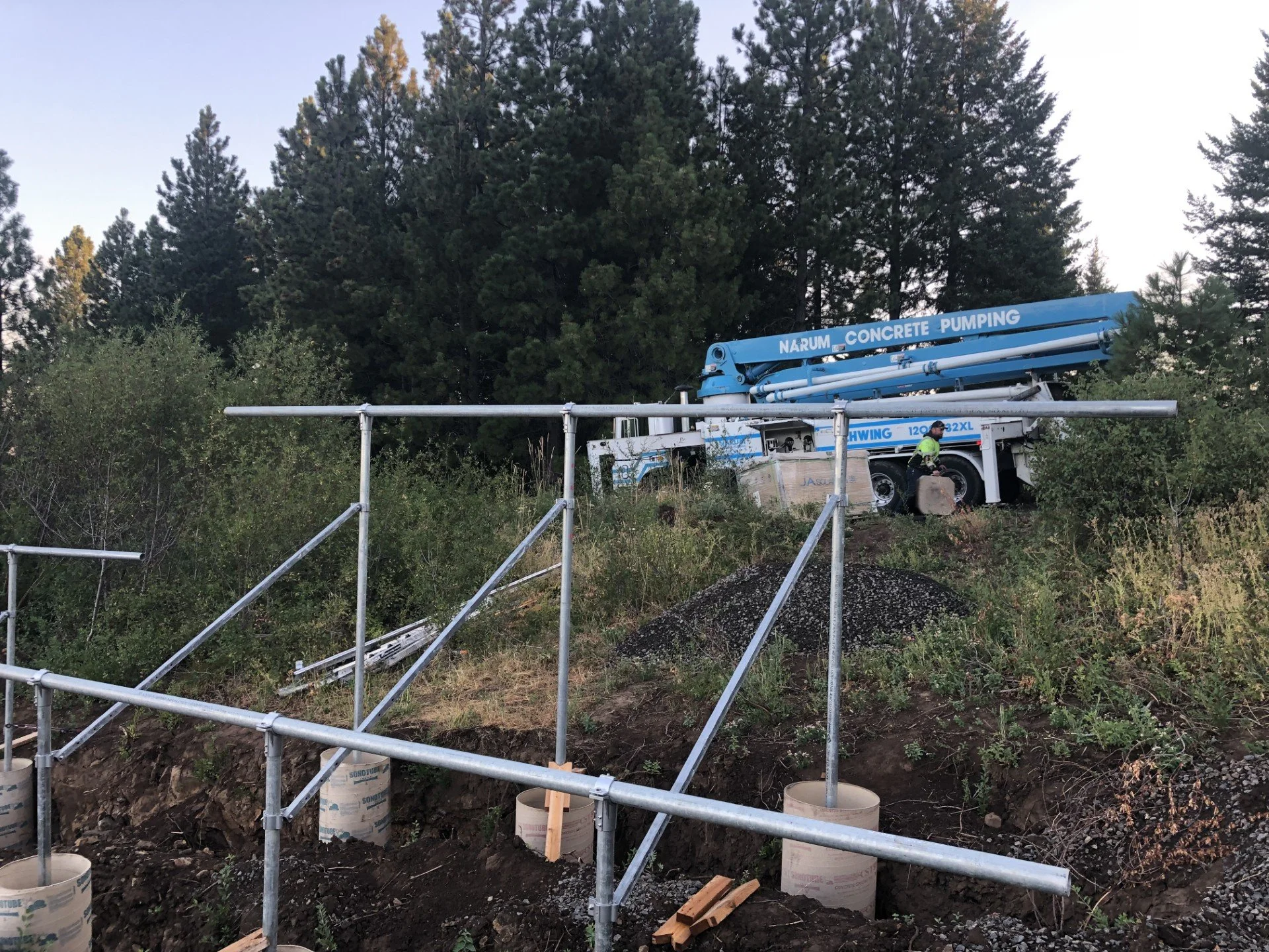'Narum Concrete' Pumping' on a hillside using their pump truck to pour the ballast for a ground mount array of solar panels which is rated for 135mph wind loads.