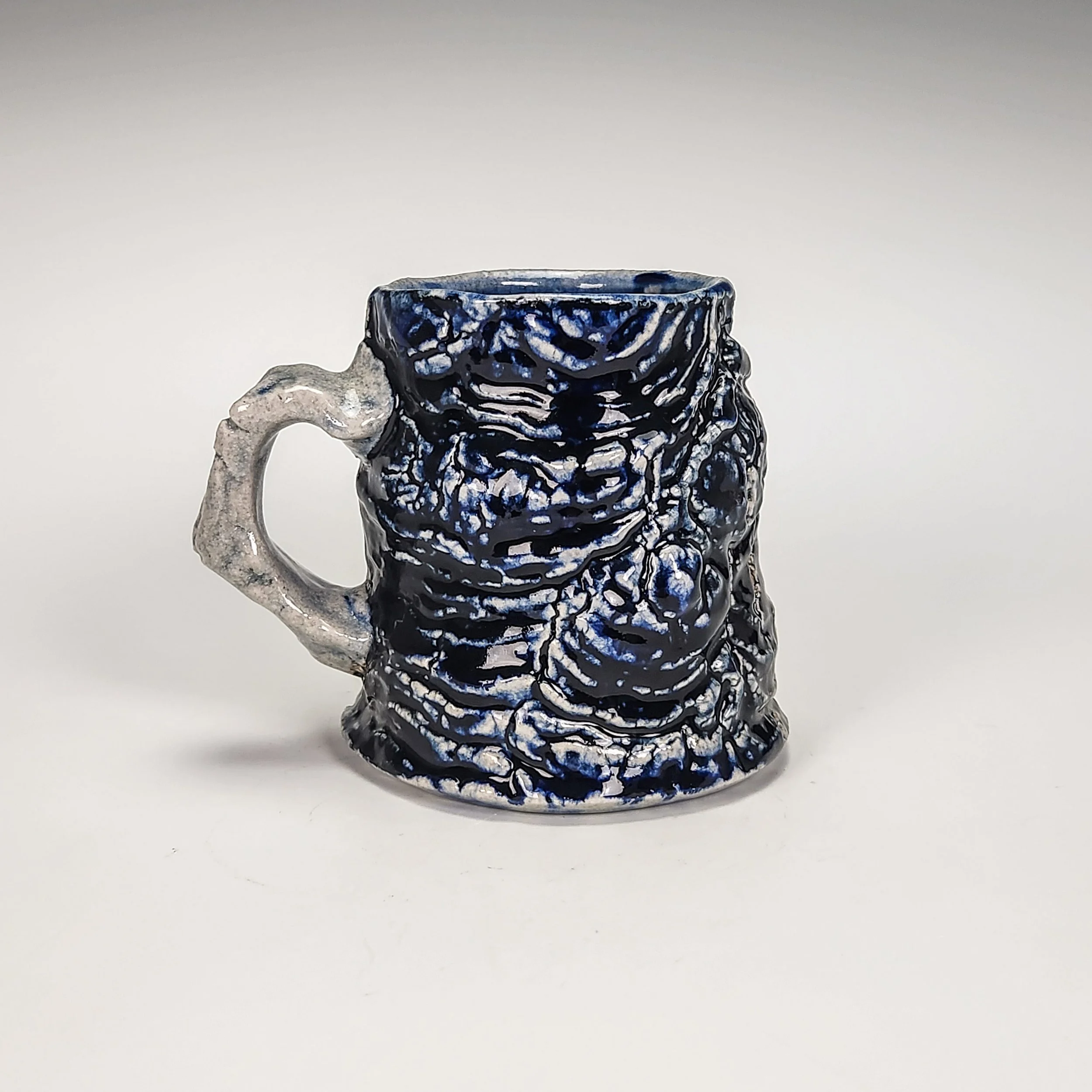 Stromatolite mug. Texture captured from stromatolite fossils in the Petrified Sea Gardens, Saratoga Springs, NY. Cone 10 soda fired, 2025. 