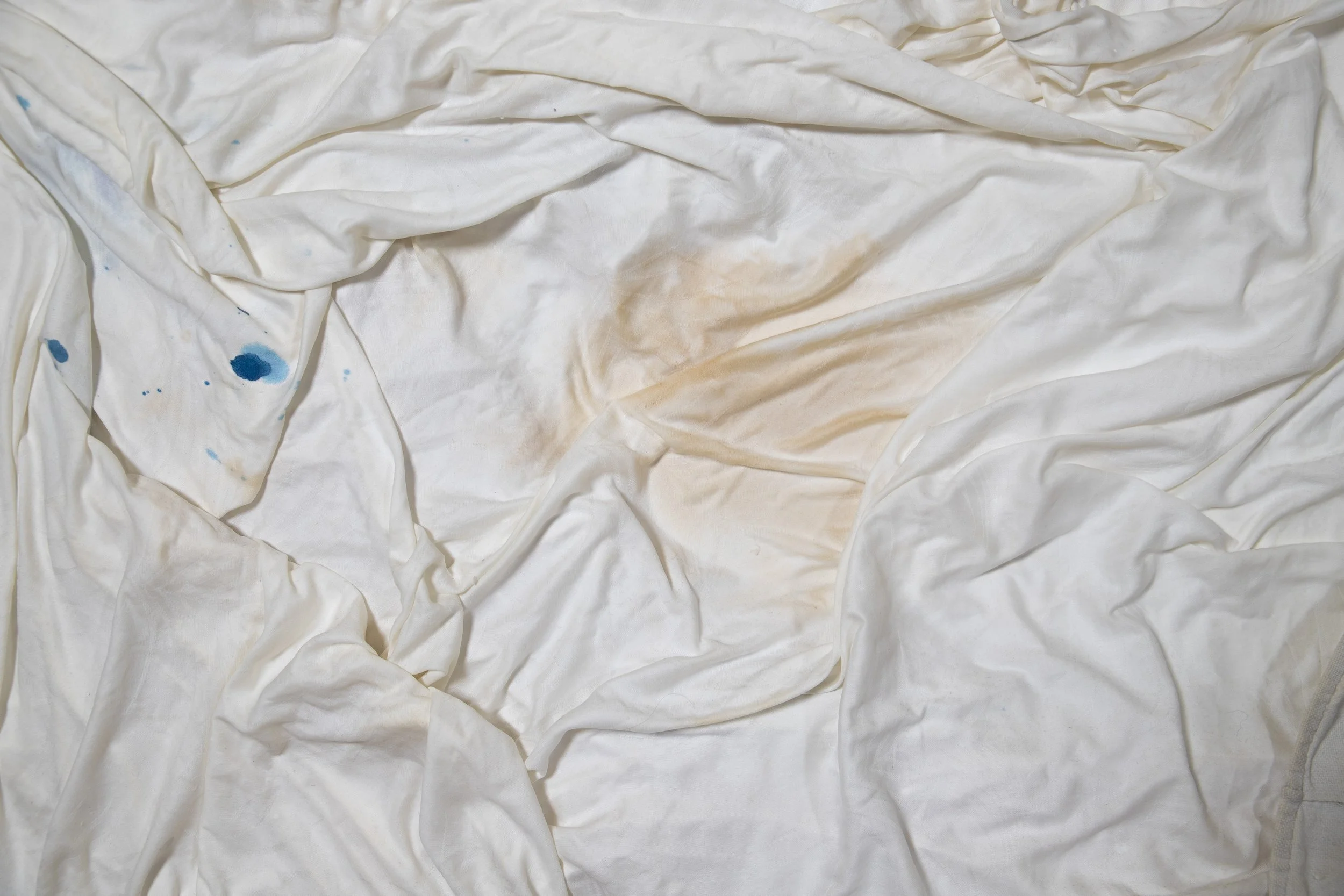Verwanzte weiße Bettwäsche mit blauen und braunen Flecken
