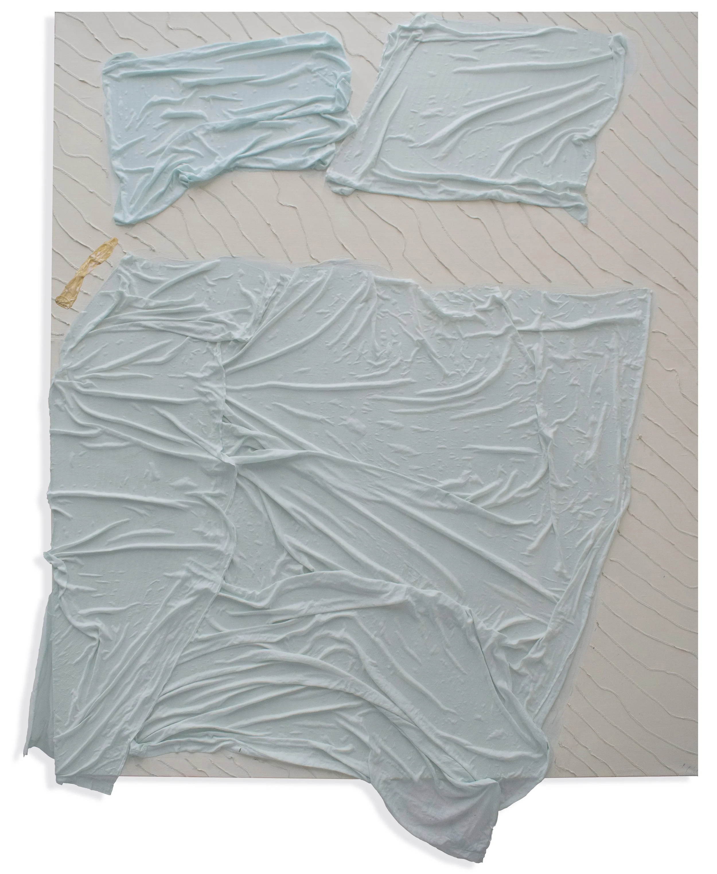 Mehrere weiße, zerknitterte Plastik- oder Stoffrollen auf einer weißen Holzoberfläche.