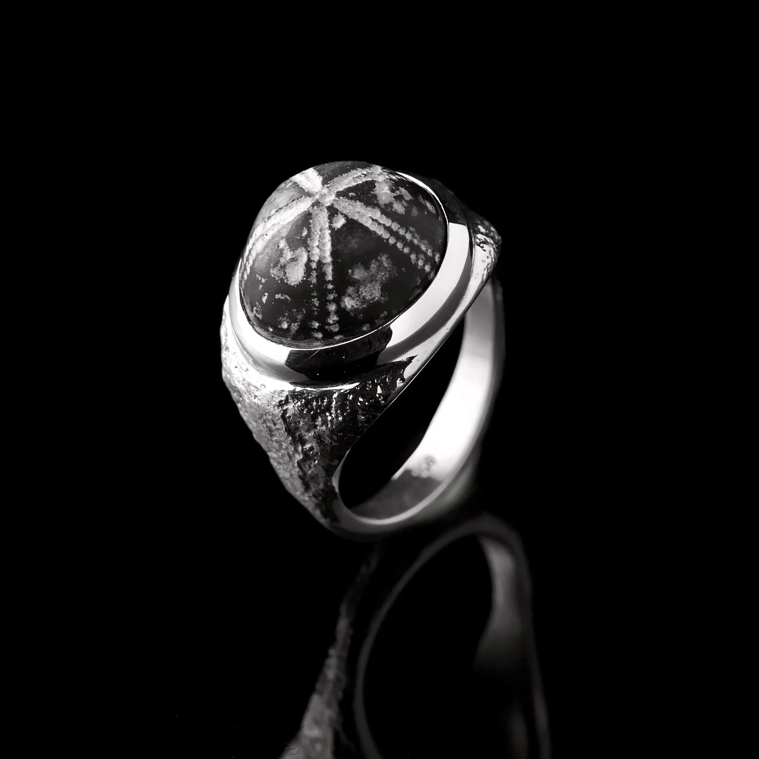 Strukturierter Sandgussring mit versteinertem Seeigel