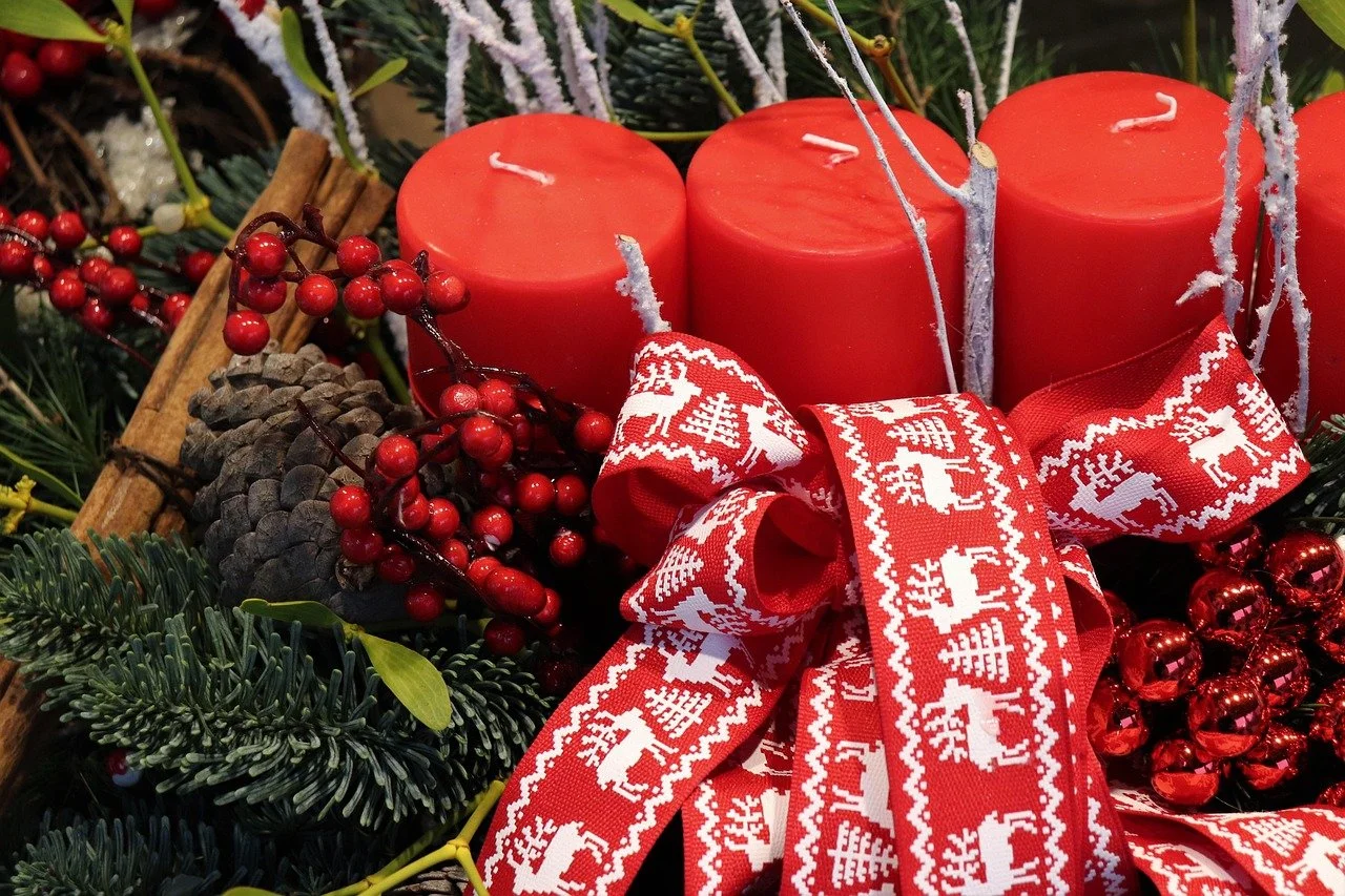 A Christmas centerpiece featuring three red candles, holiday gift ideas candles and clothing, unique gifts for birthdays and celebrations, candle and apparel gift set, cozy gift box for her, self care gift set with candle