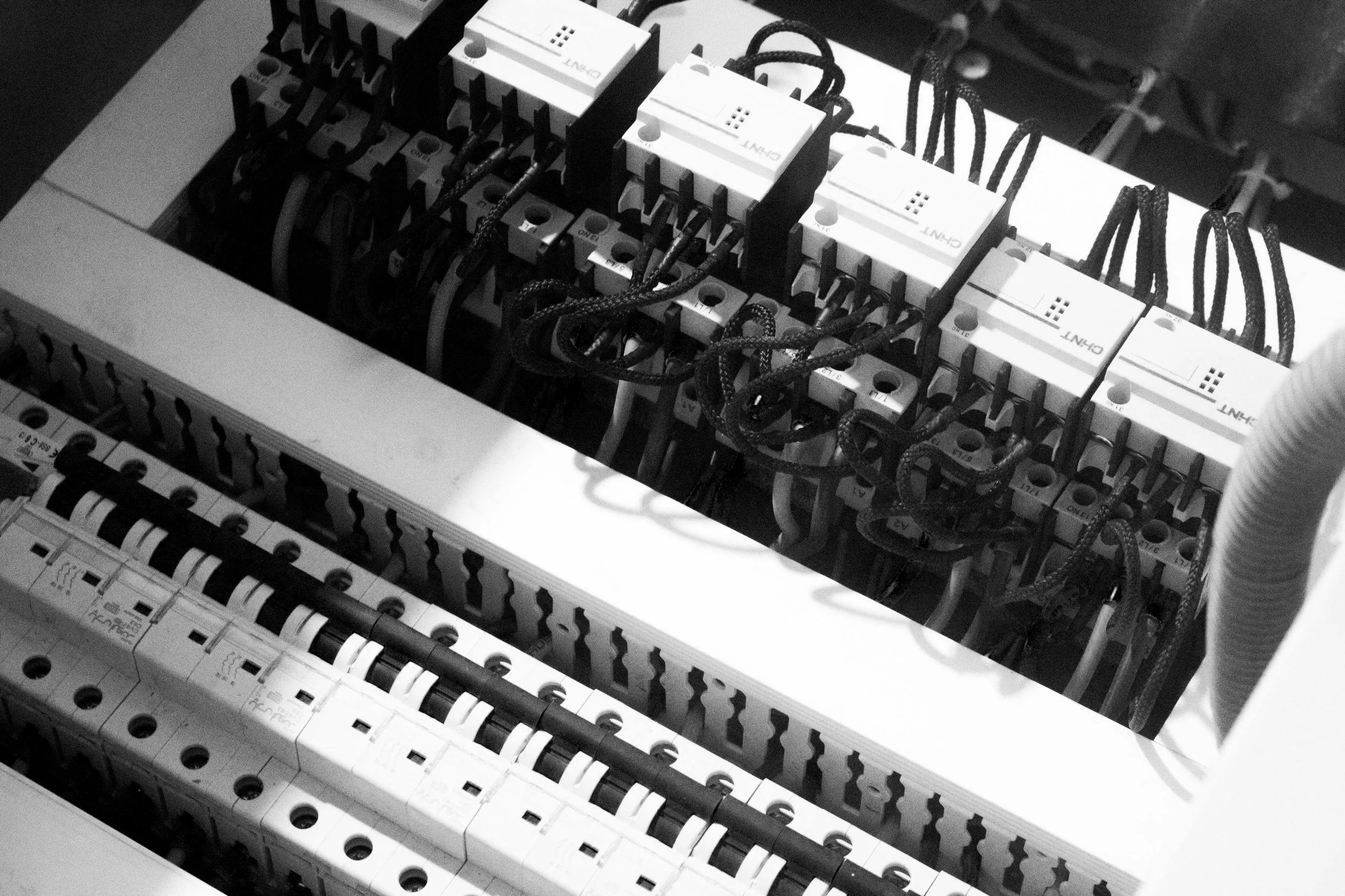 Close-up of an electrical circuit breaker panel with wires and components visible inside.