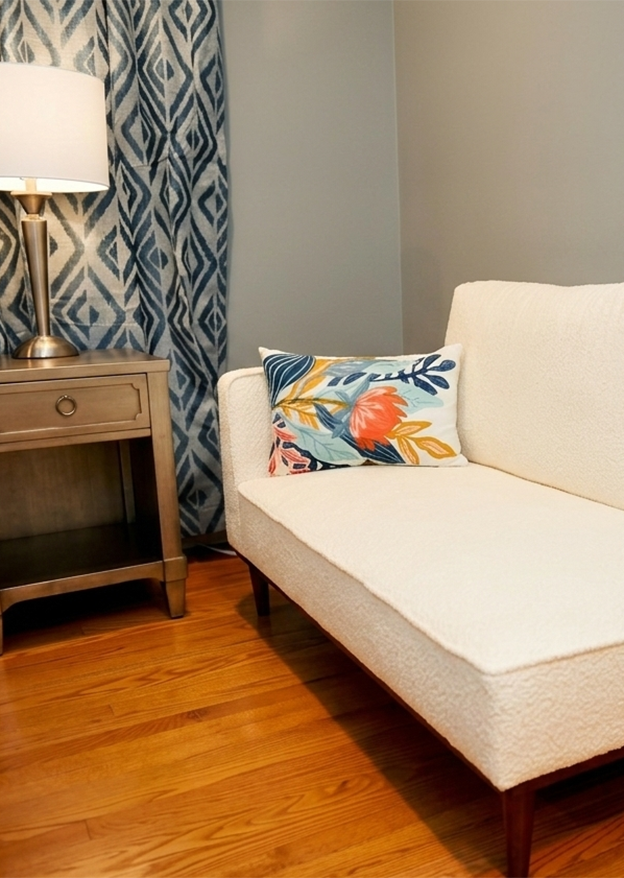 Chaise lounge with colorful pillow in bedroom