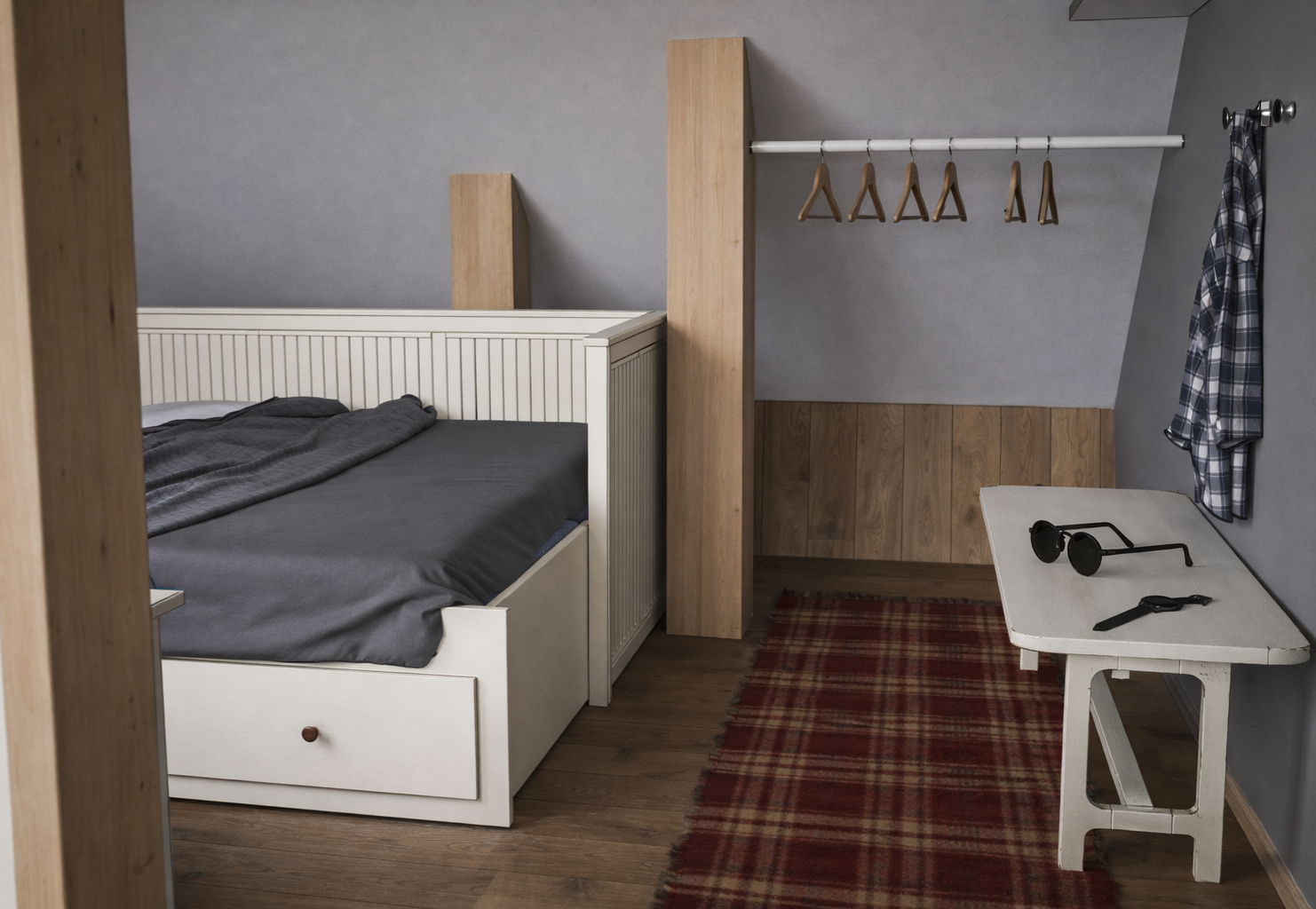 A cozy bedroom with a white bed frame, gray bedding, and a gray wall. There is a small white table with sunglasses and a watch, a plaid shirt hanging on a hook, and a clothing rod with wooden hangers. A red plaid rug is on the wooden floor.