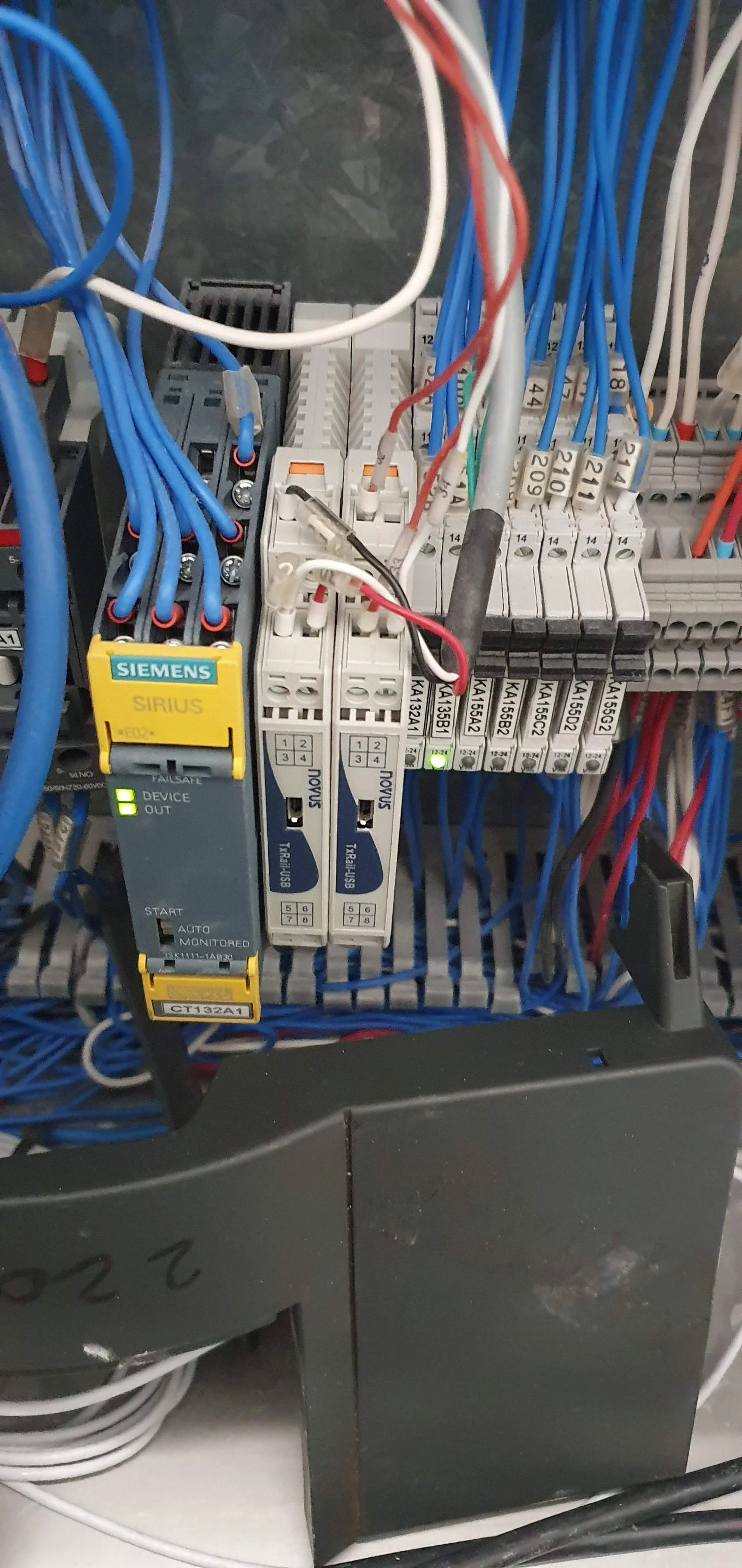 Panel eléctrico con cables de colores, relés, y dispositivos de control y protección.