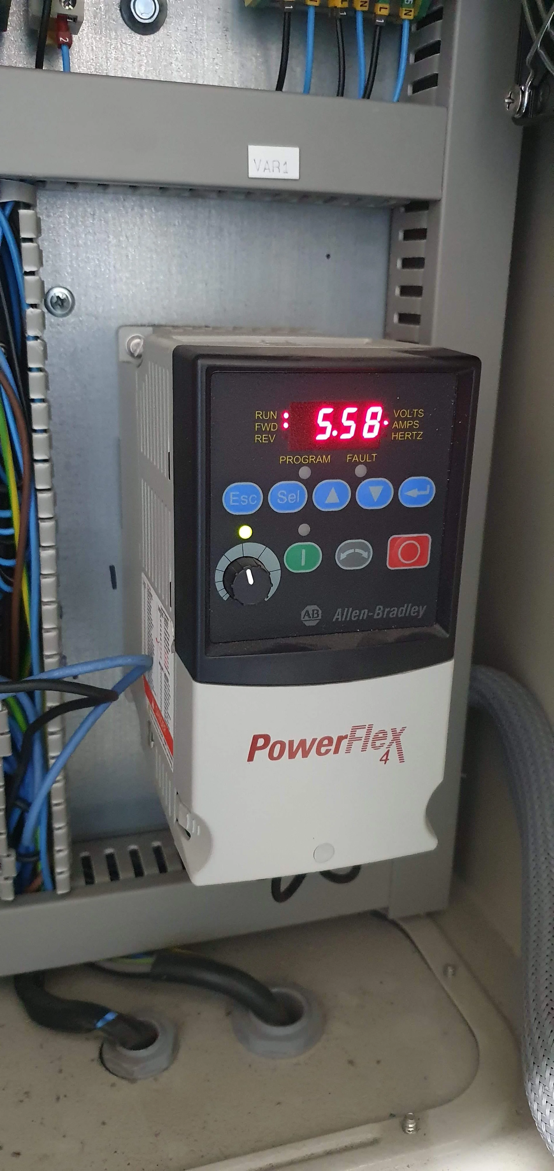 Variador de frecuencia Allen-Bradley PowerFlex 4, ajustado a 5.58 amperes, en un gabinete eléctrico con cables y componentes eléctricos.