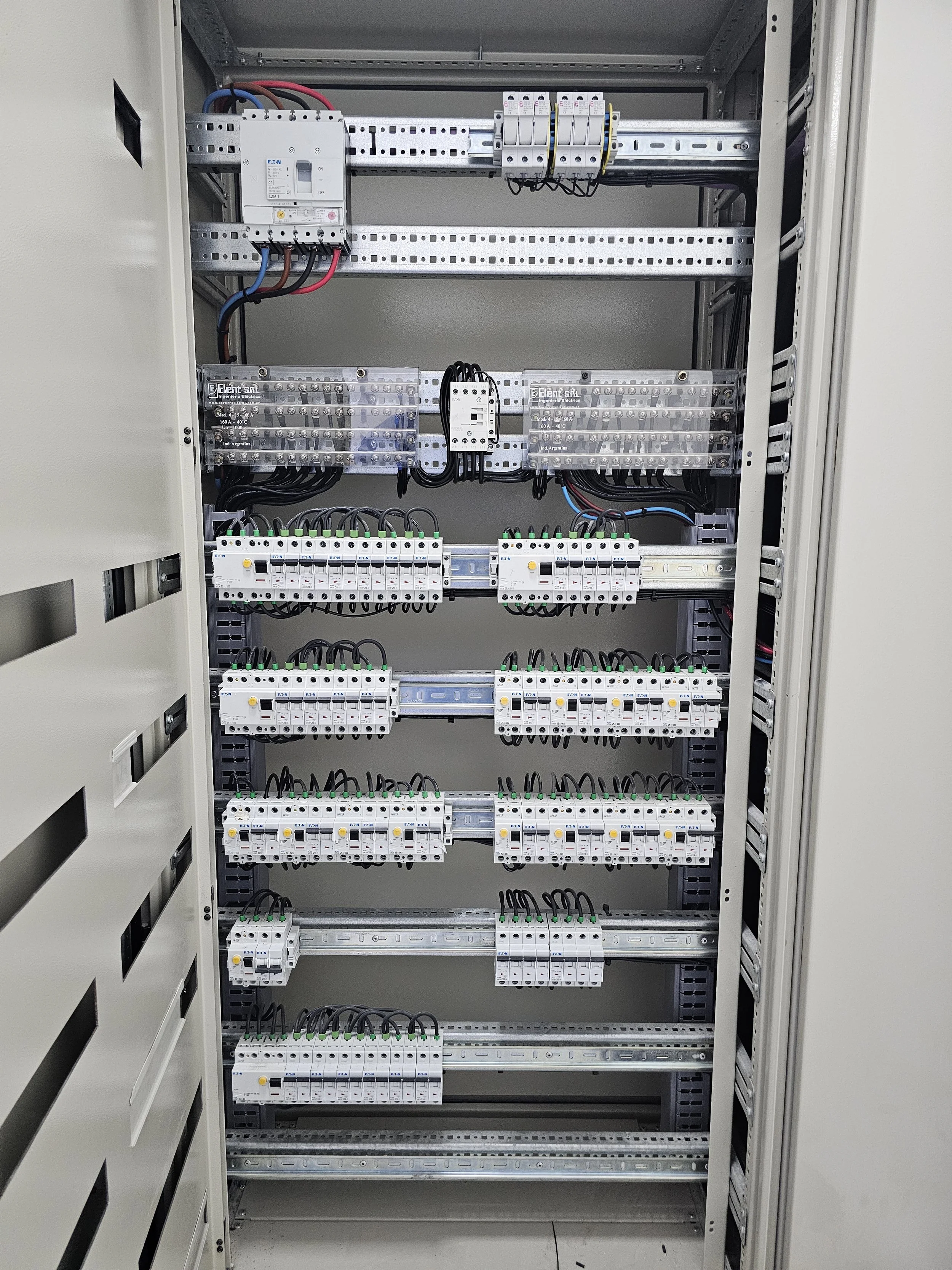 Cuadro eléctrico con componentes y cables organizados en una infraestructura metálica.