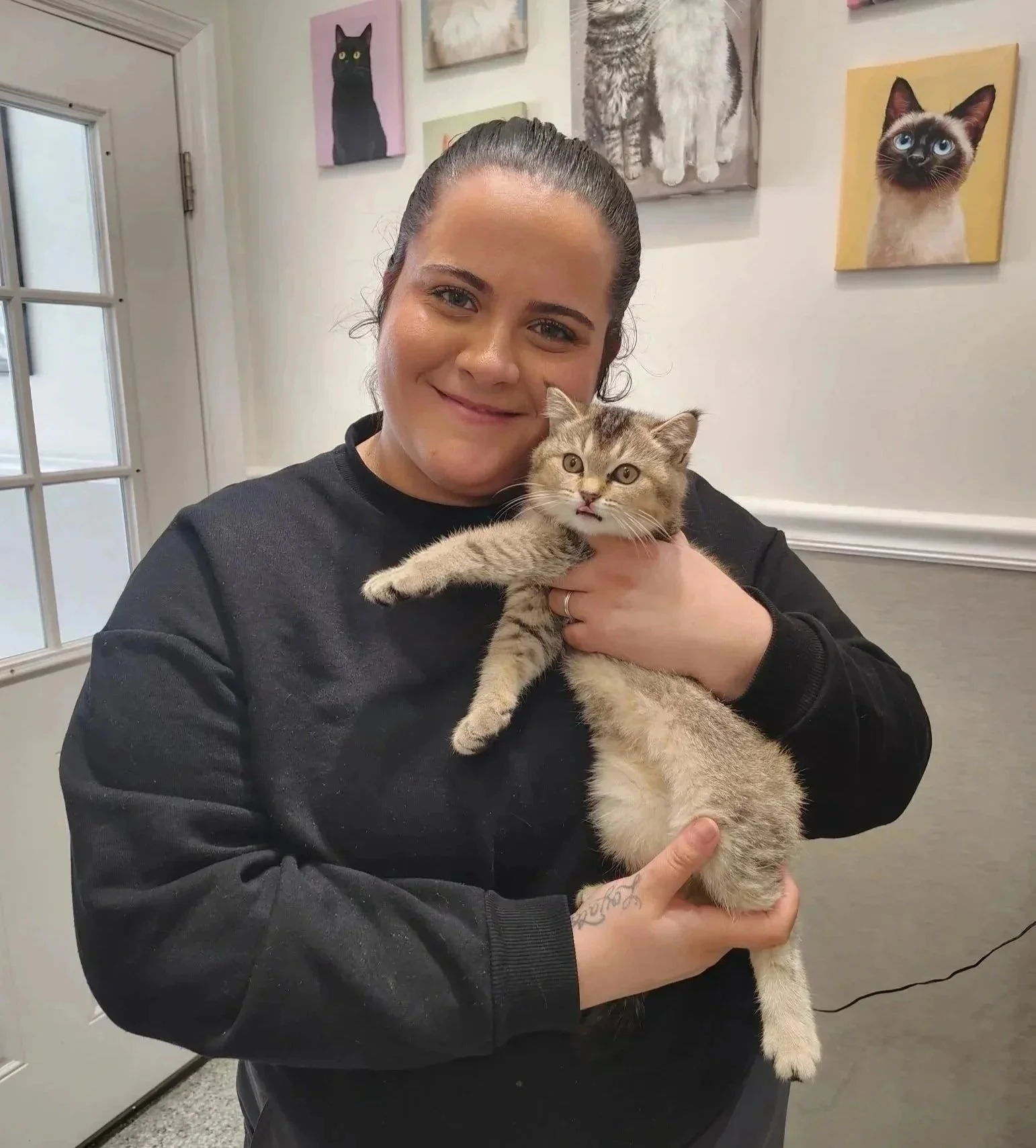 A veterinary team member gently holds a cat inside The Veterinarian Pet Alliance clinic in Newark, NJ.