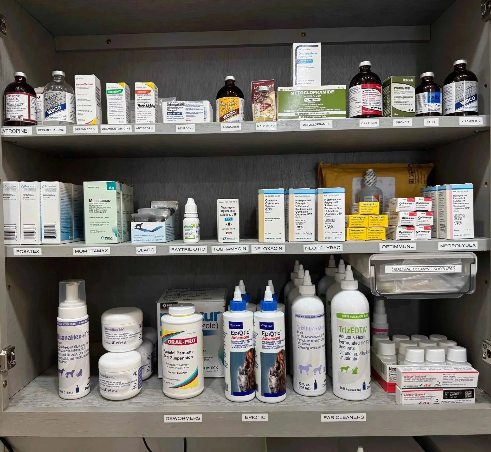Labeled veterinary medications and supplies are organized inside a clinic cabinet at Veterinarian Pet Alliance in Newark.