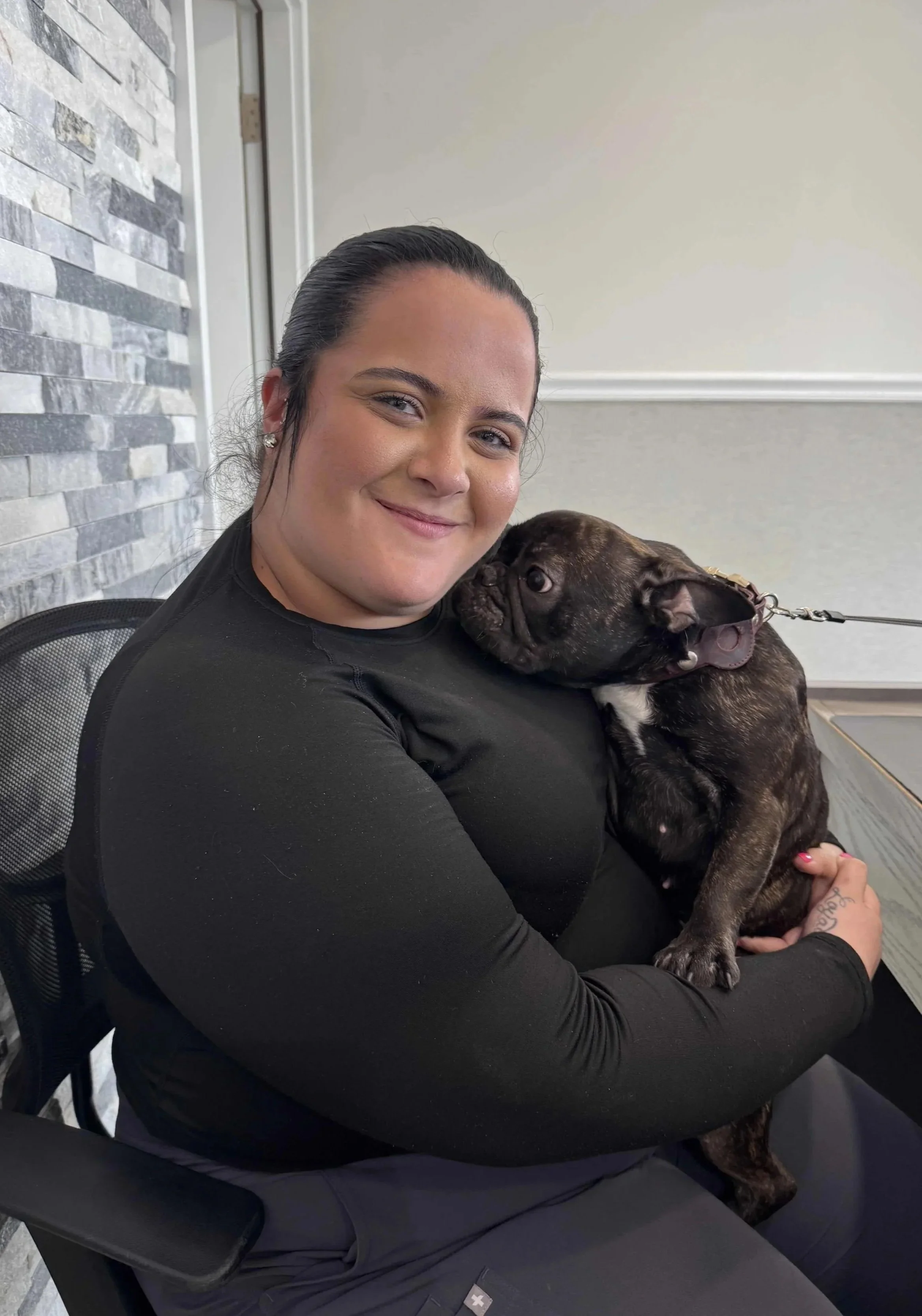 Veterinary team member holding a dog before a pet travel certificate appointment in Newark, NJ.