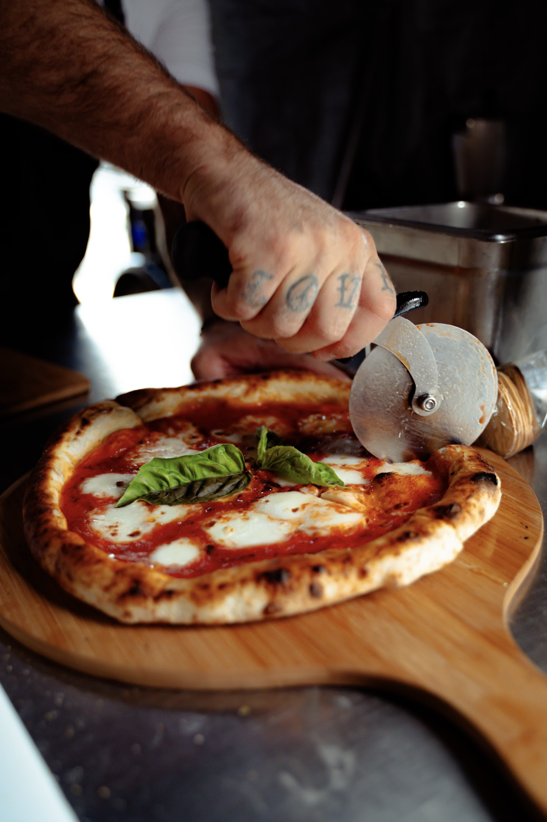 image of Bocconcini pizza being sliced at Akash Winery