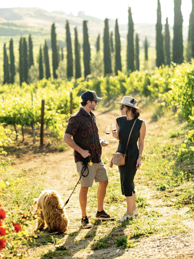 Couple enjoying wine and walking their dog at Akash Winery