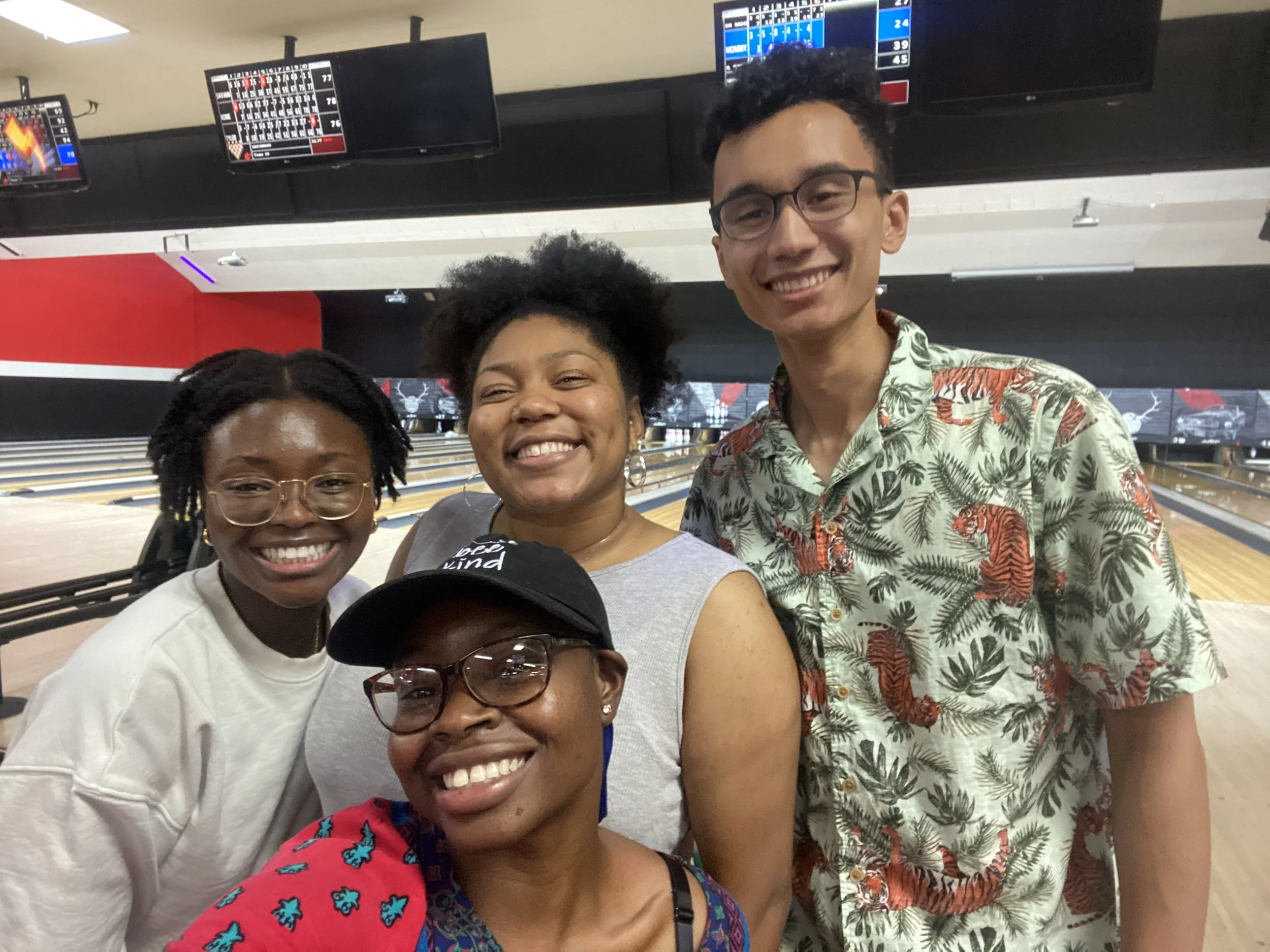 Mope an Robert smiling and posing together at a bowling alley with Mope's friends.