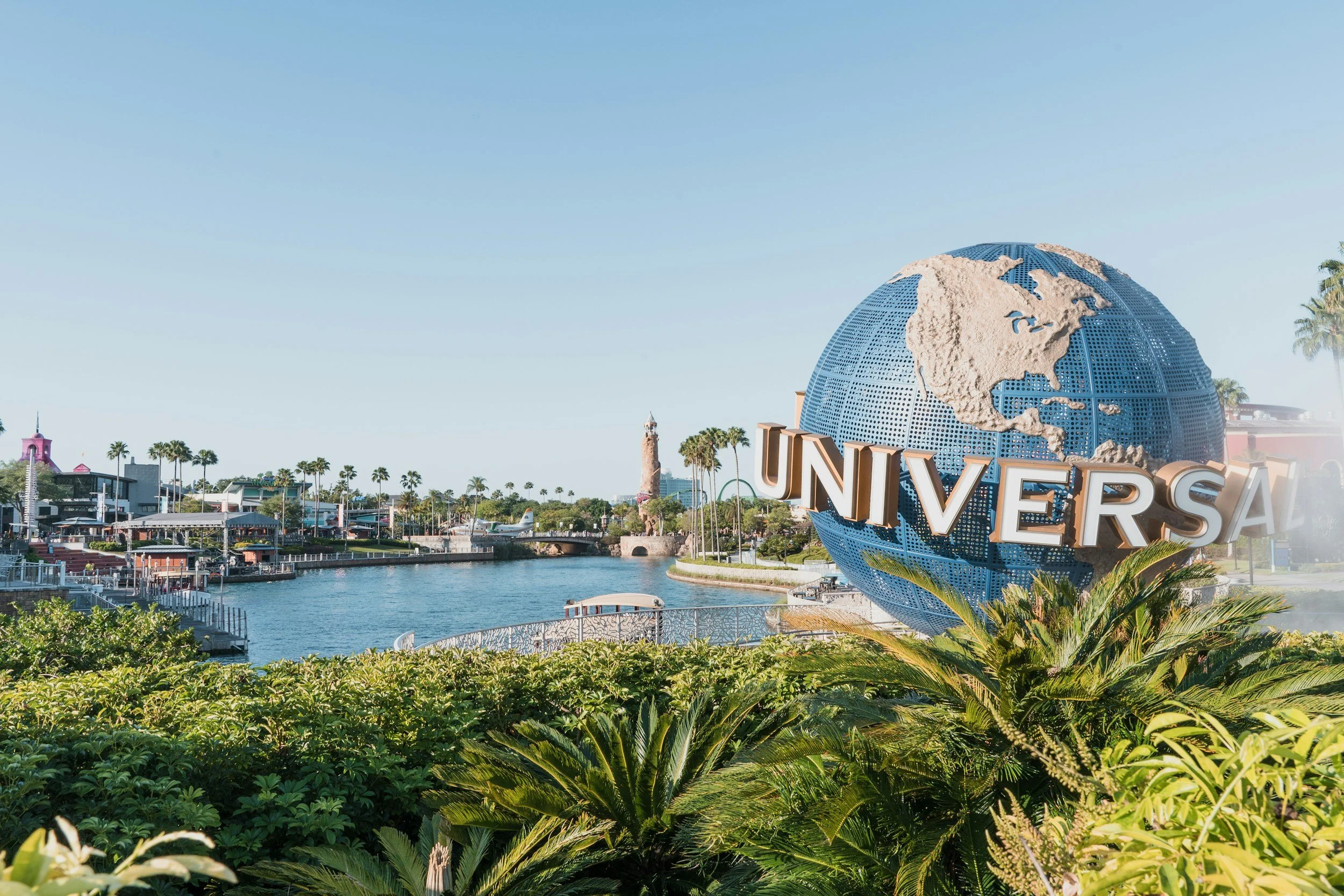 Universal Studios globe logo with water and palm trees in the background