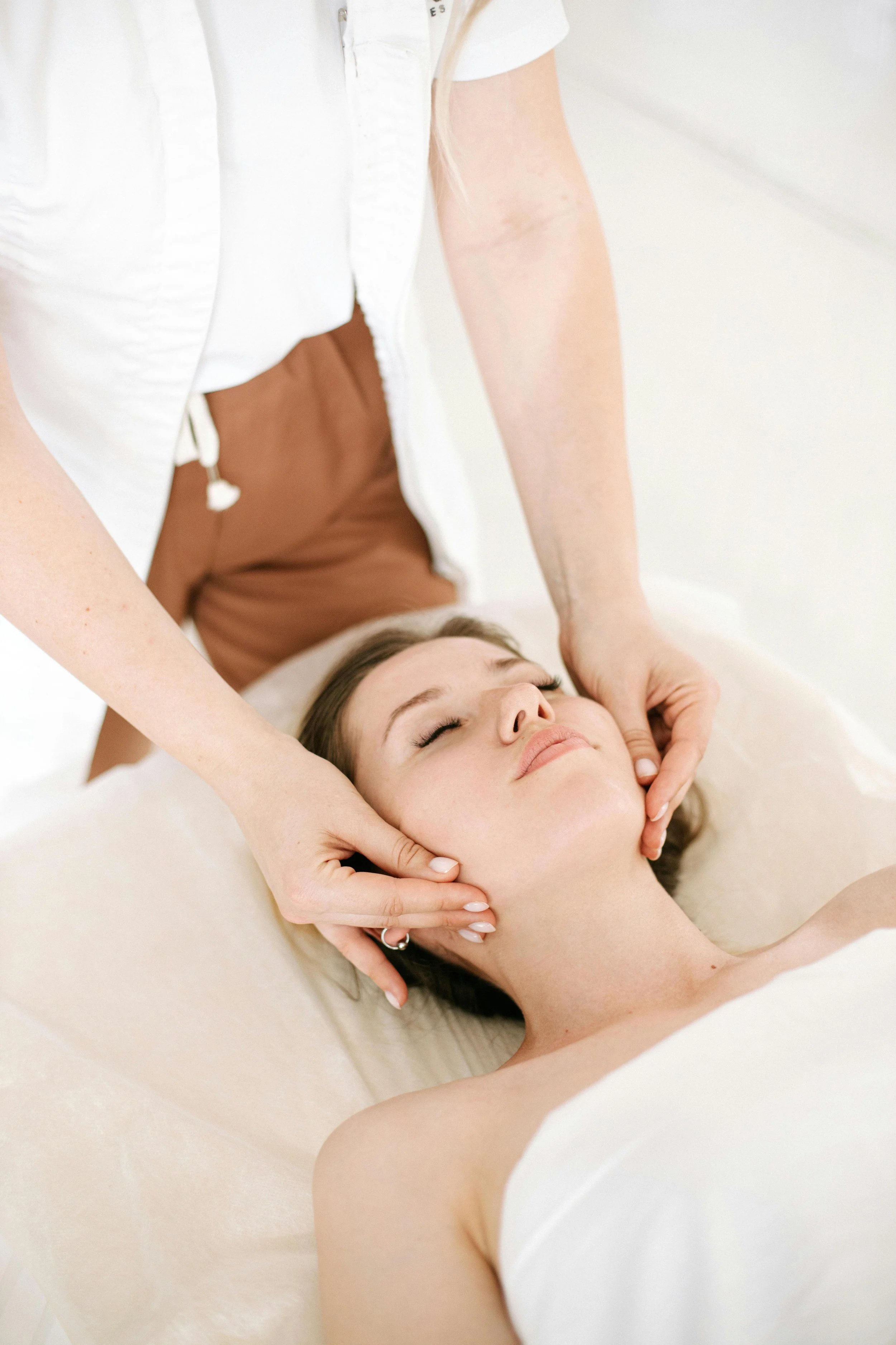 female lying face up receiving a face massage