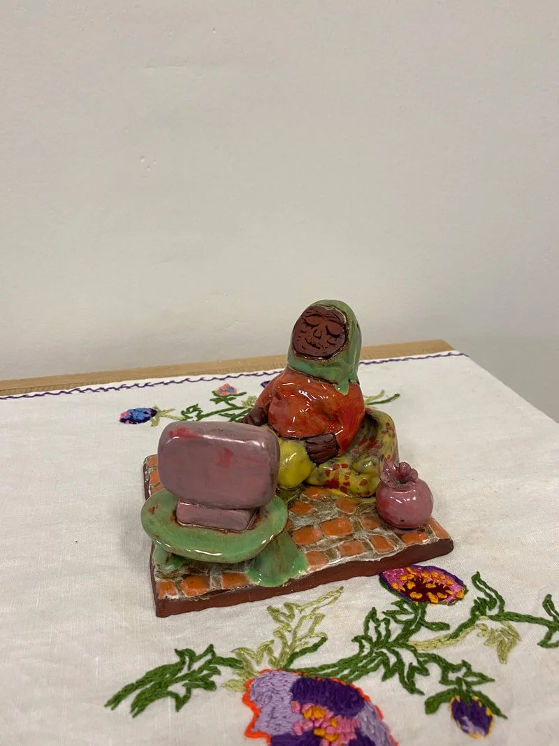 Jasmine Djavahery,  بعد از ظهر (afternoon), ceramic, 2022, and tablecloth, date unknown, embroidered by artist's grandmother, Parvaneh Shahbandi