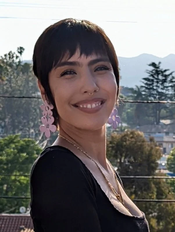 Image of artist Jasmine Godinez-Gomez smiling at camera outside.
