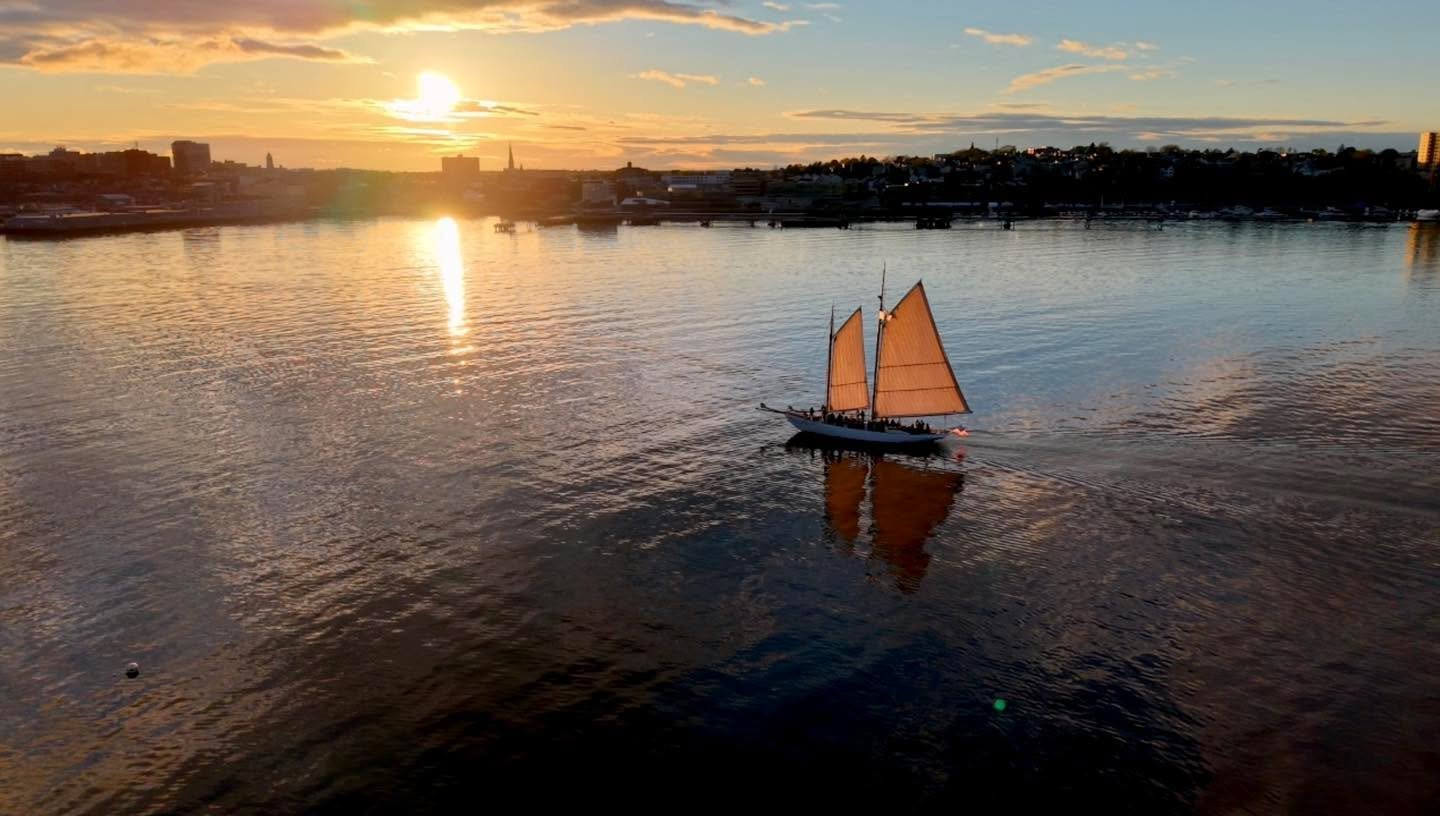 A spectacular perspective of the Portland, Maine waterfront at sunset. Watching this traditional schooner navigate the calm waters of Casco Bay perfectly captures the spirit of the Maine coast.

Elevate your maritime, real estate, or commercial proje