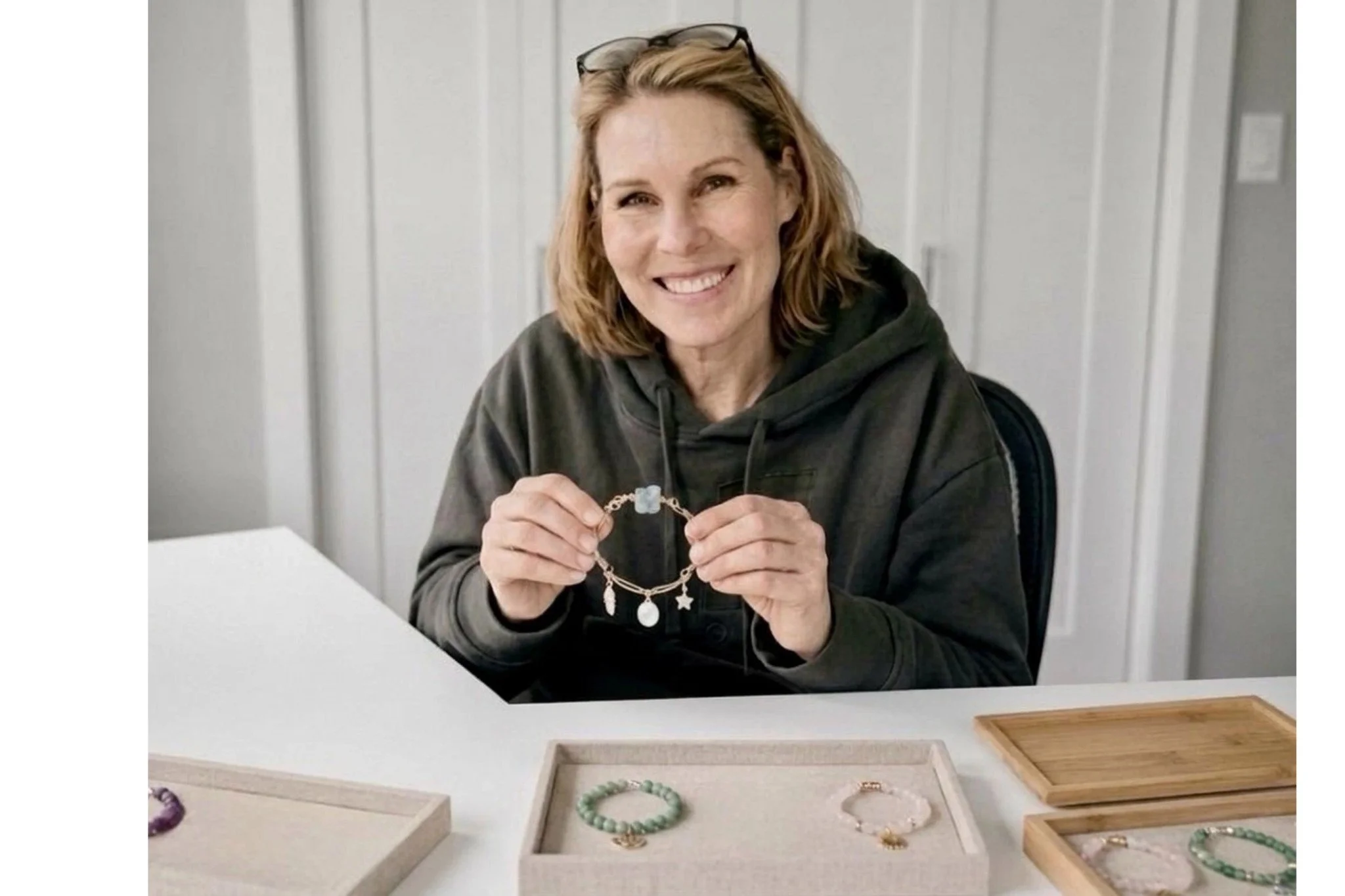 Bound Together Studio Founder at desk holding handcrafted bracelet