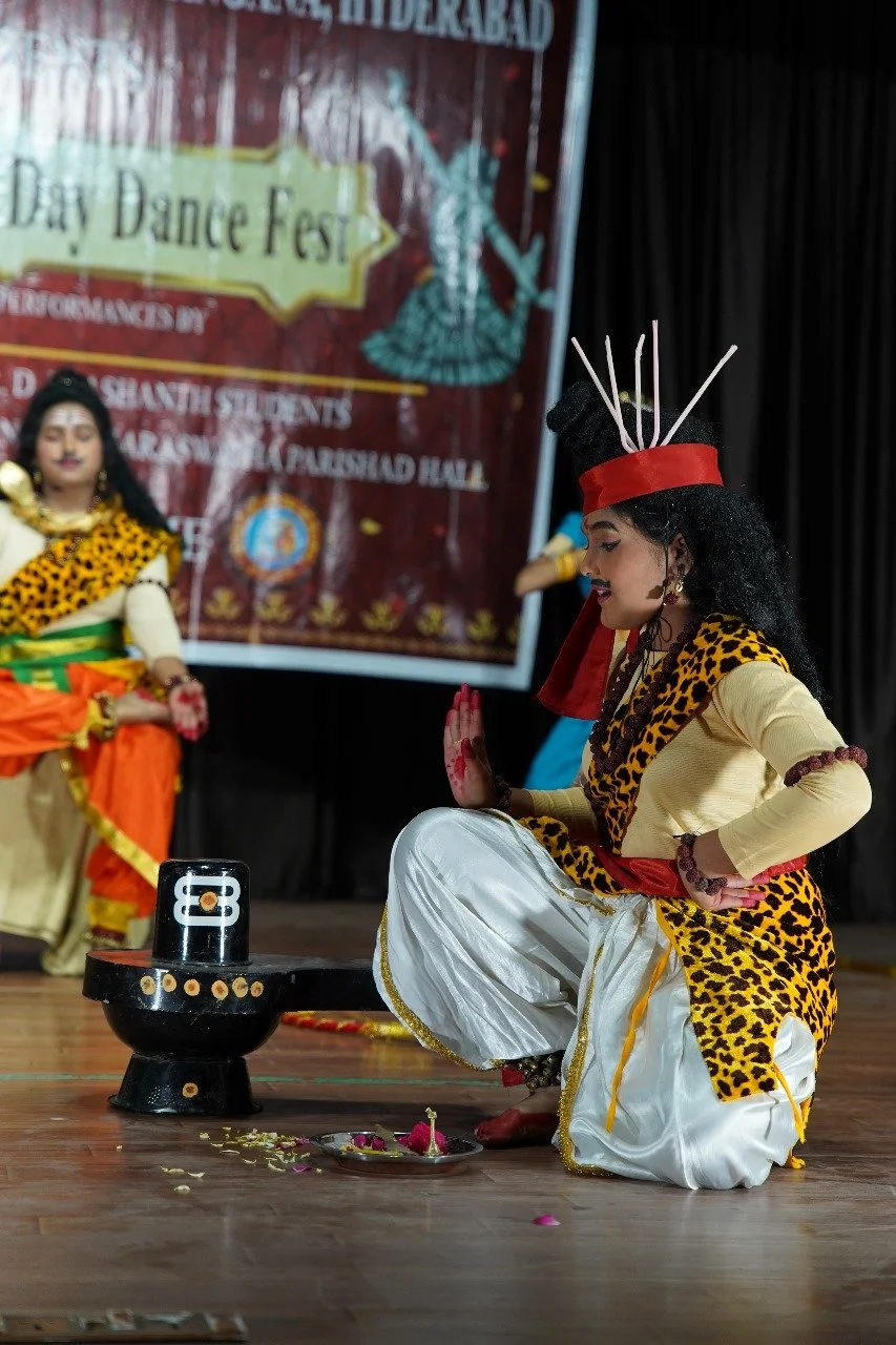 Women dressed in traditional Indian attire perform a dance on stage at a cultural event.